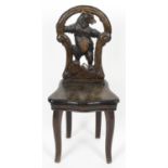 An early 20th century Black Forest bear carved wood musical child’s chair.