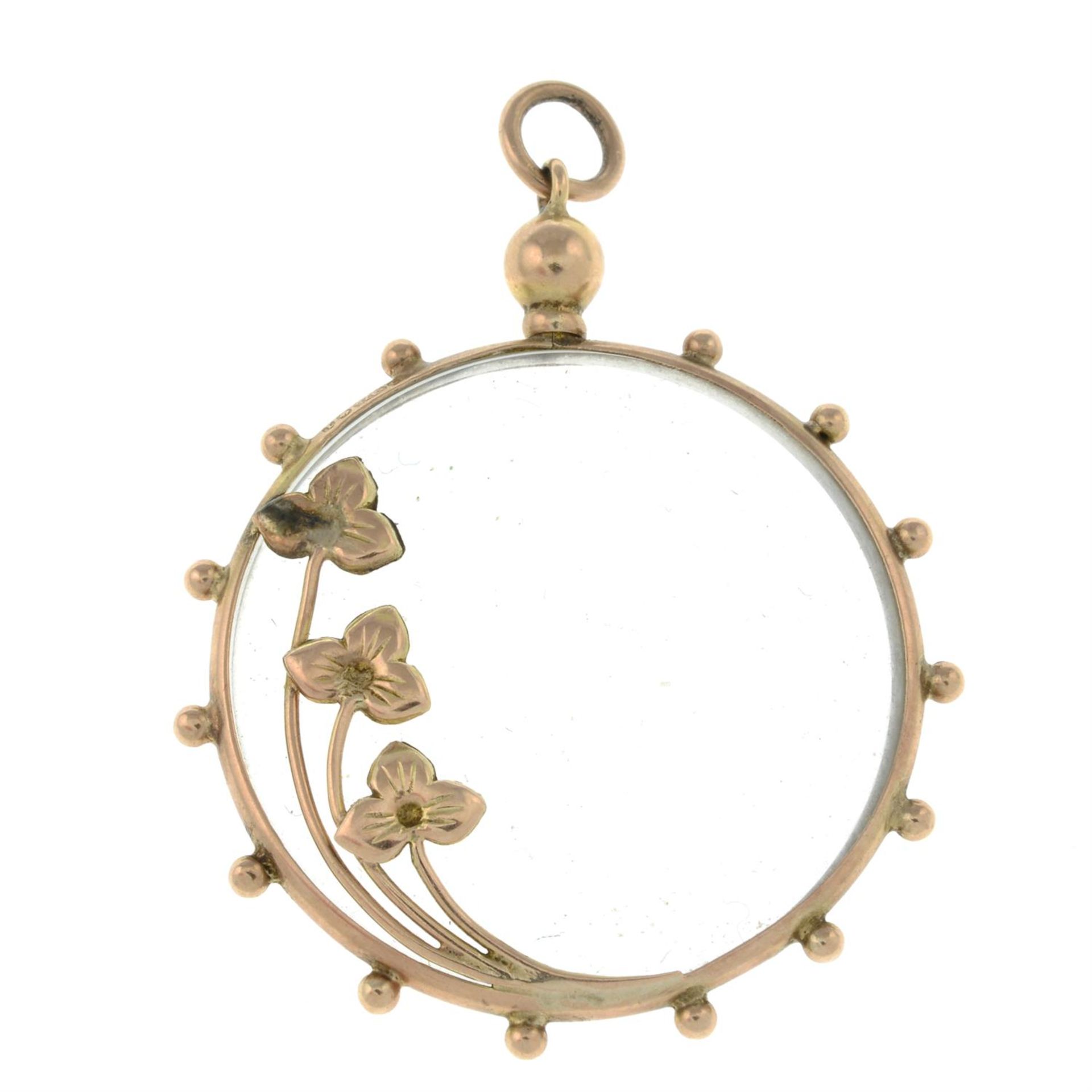 An early 20th century gold pendant, with floral design and glazed panels.