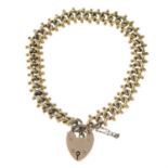 An early 20th century 9ct gold fancy-link charm bracelet, with heart-shaped padlock clasp.