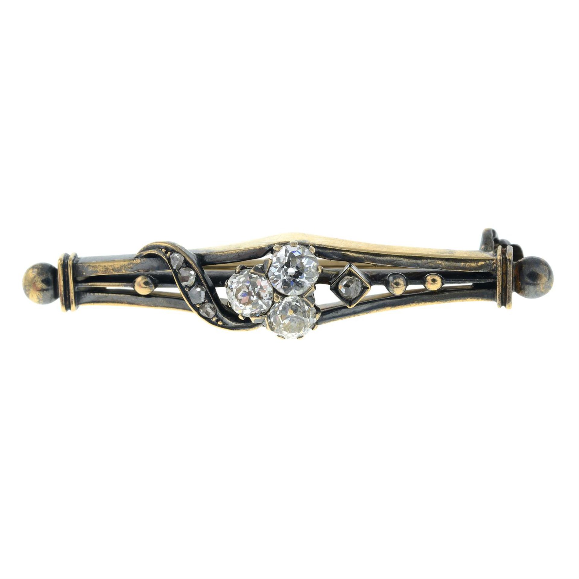 An early 20th century gold vari-cut diamond bar brooch, with shamrock motif.