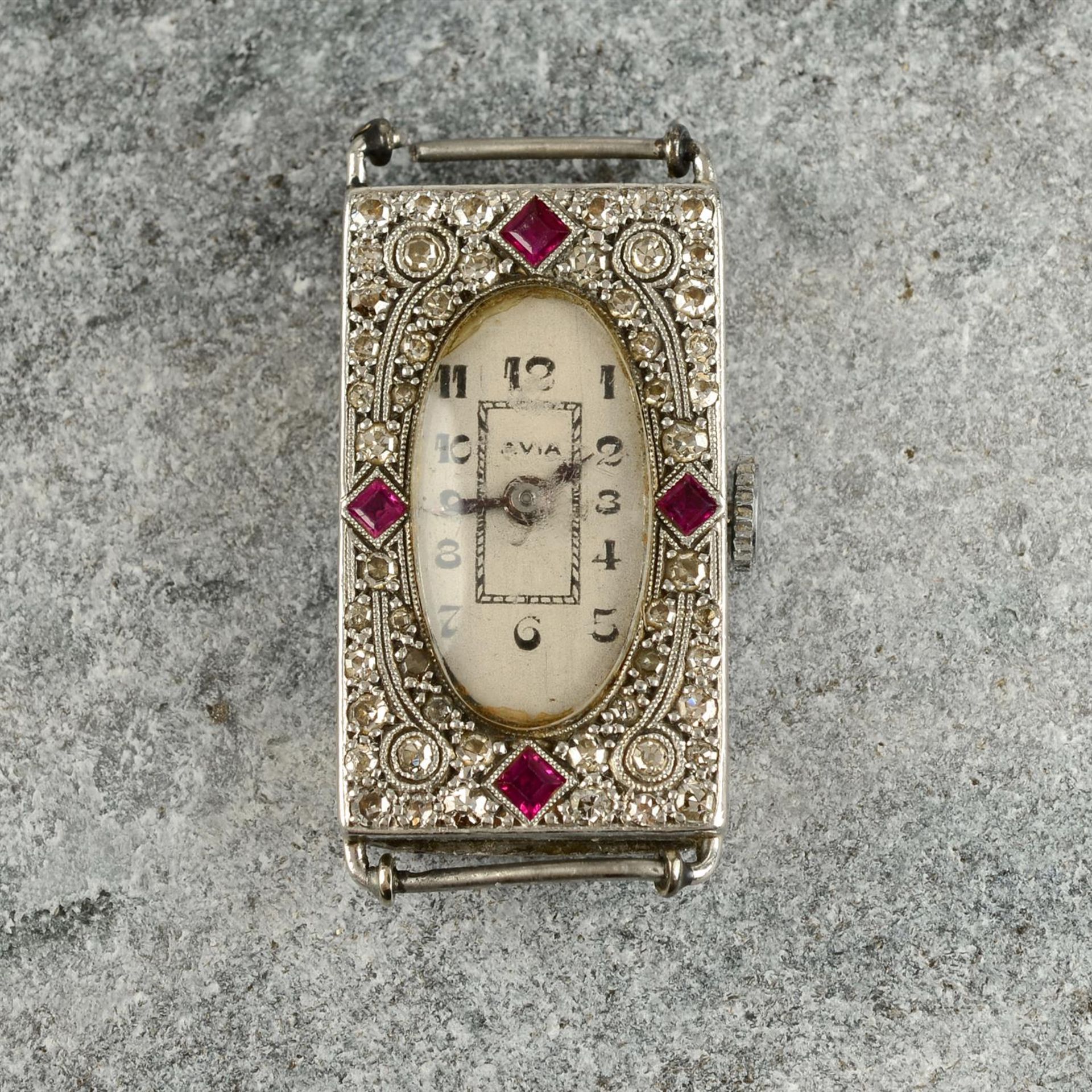 An Art Deco platinum, synthetic ruby and diamond cocktail watch head.