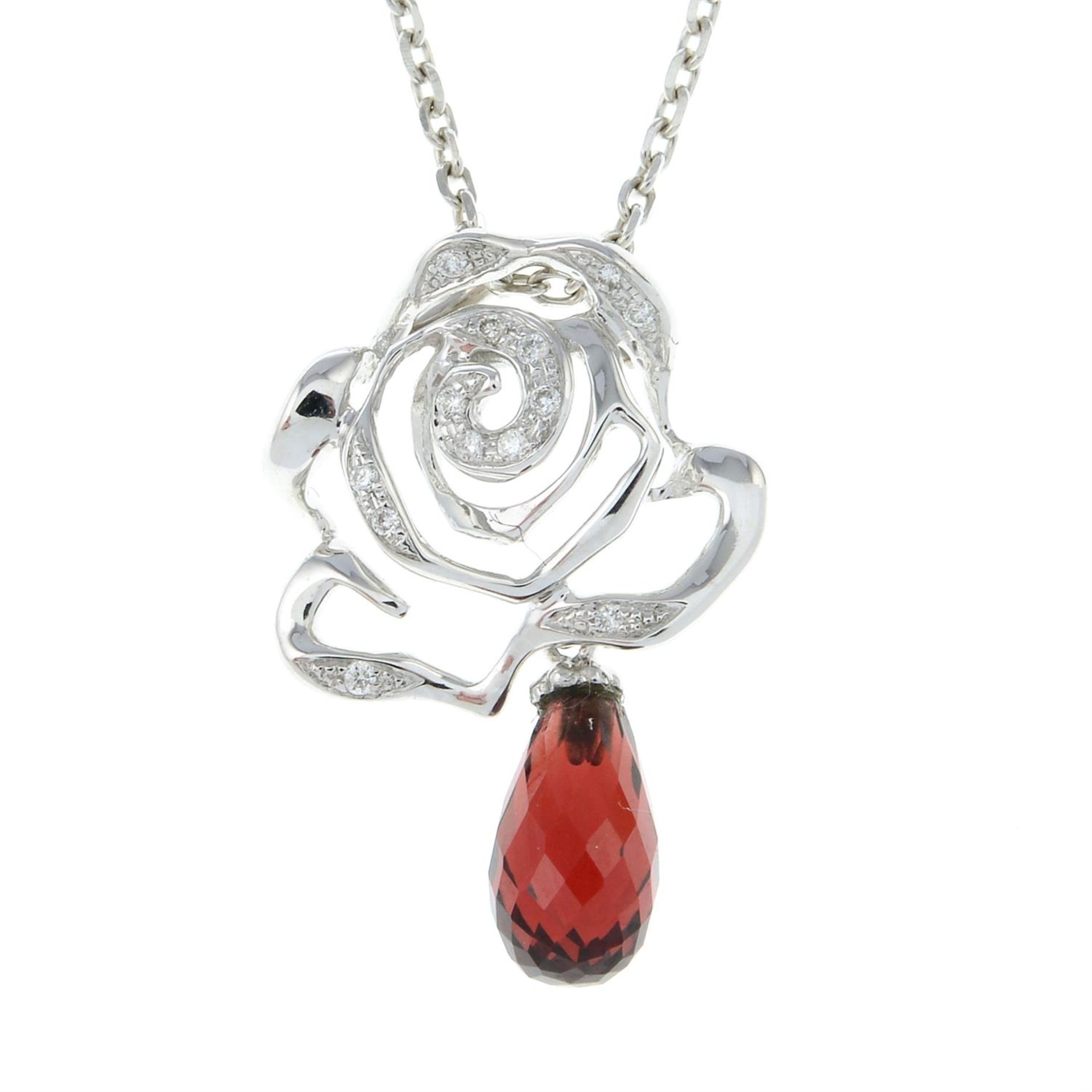 An 18ct gold garnet and diamond flower pendant, with chain.