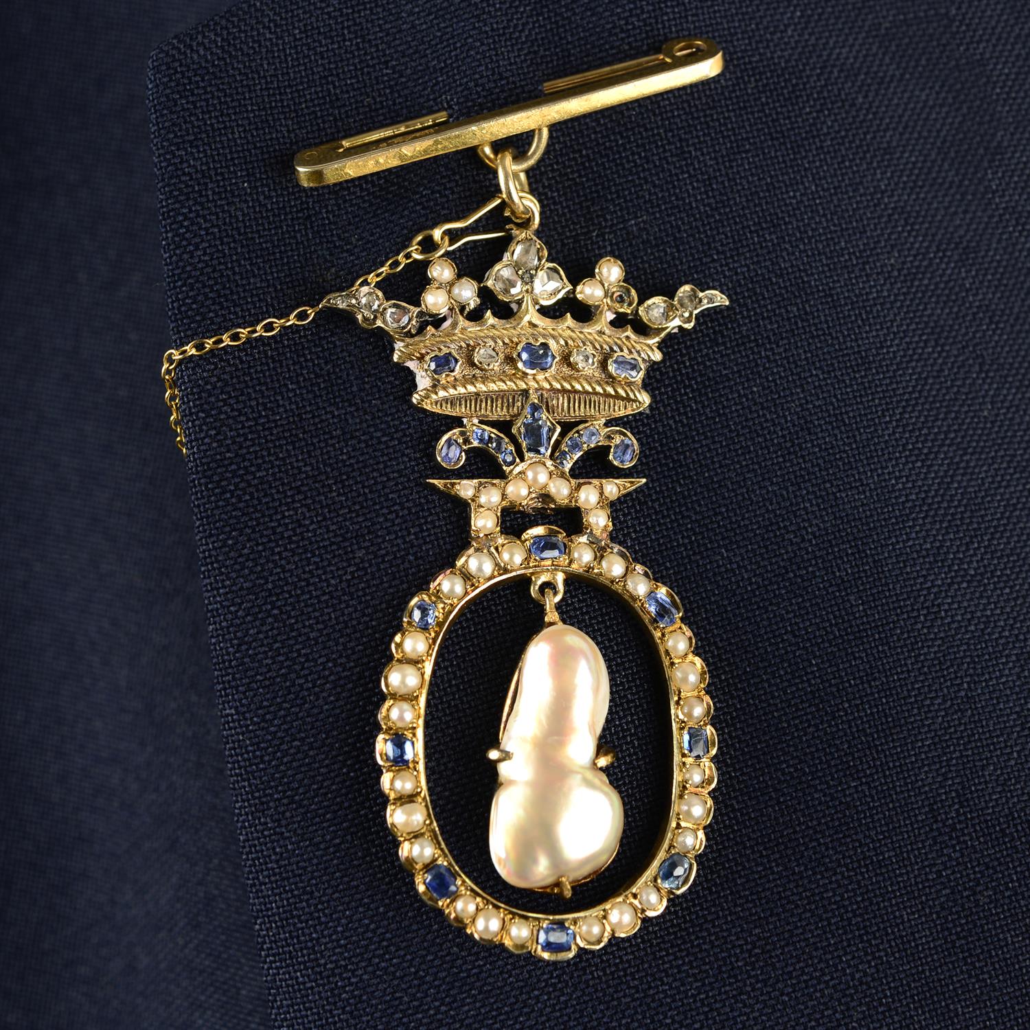 A composite early 20th century gold brooch, the central blister pearl, suspended within a split