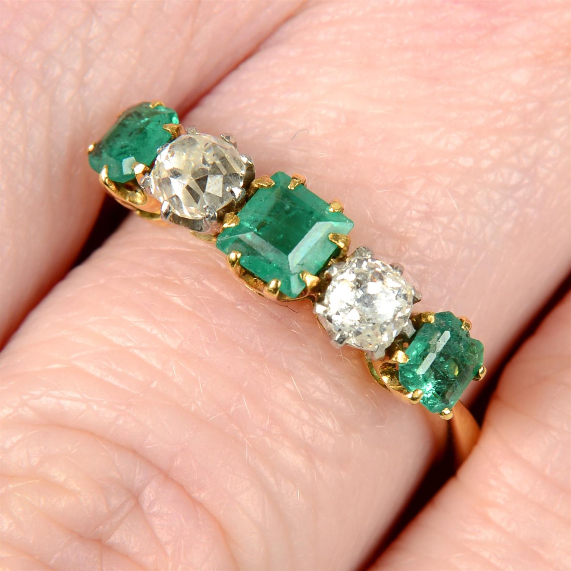 An Edwardian 18ct gold and platinum old-cut diamond and emerald five-stone ring.