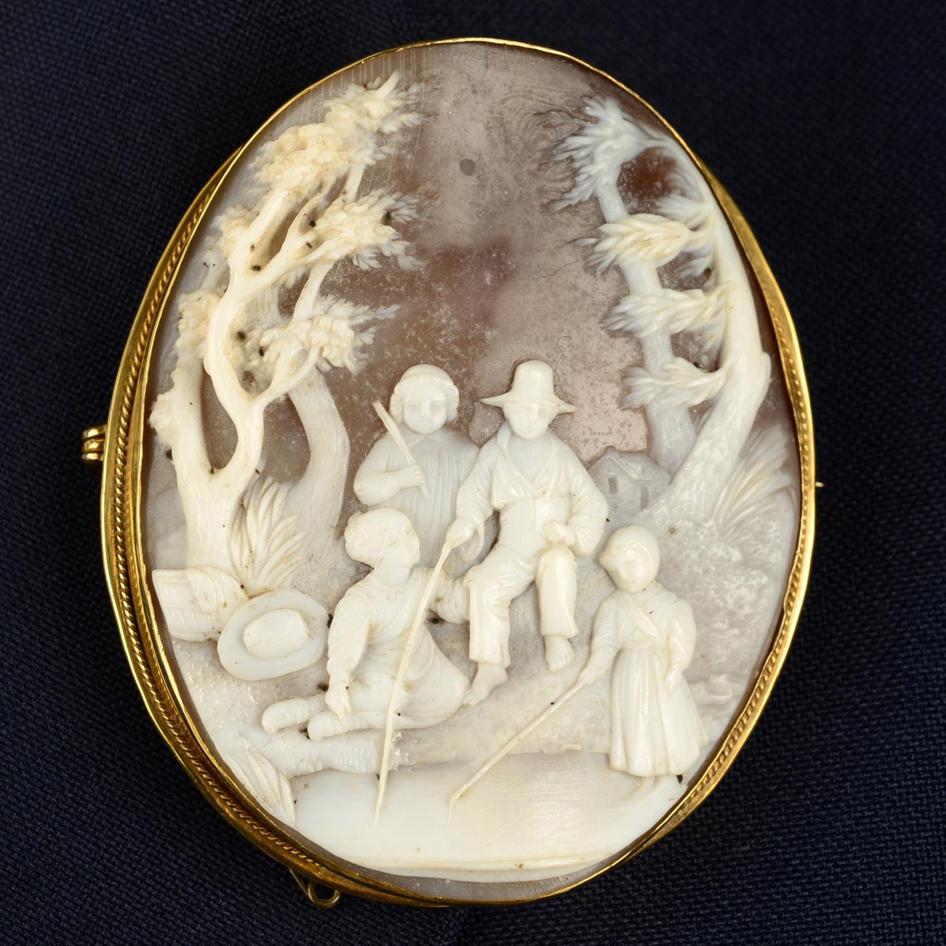 A late Victorian 9ct gold mounted shell cameo brooch, carved to depict a family fishing at a river
