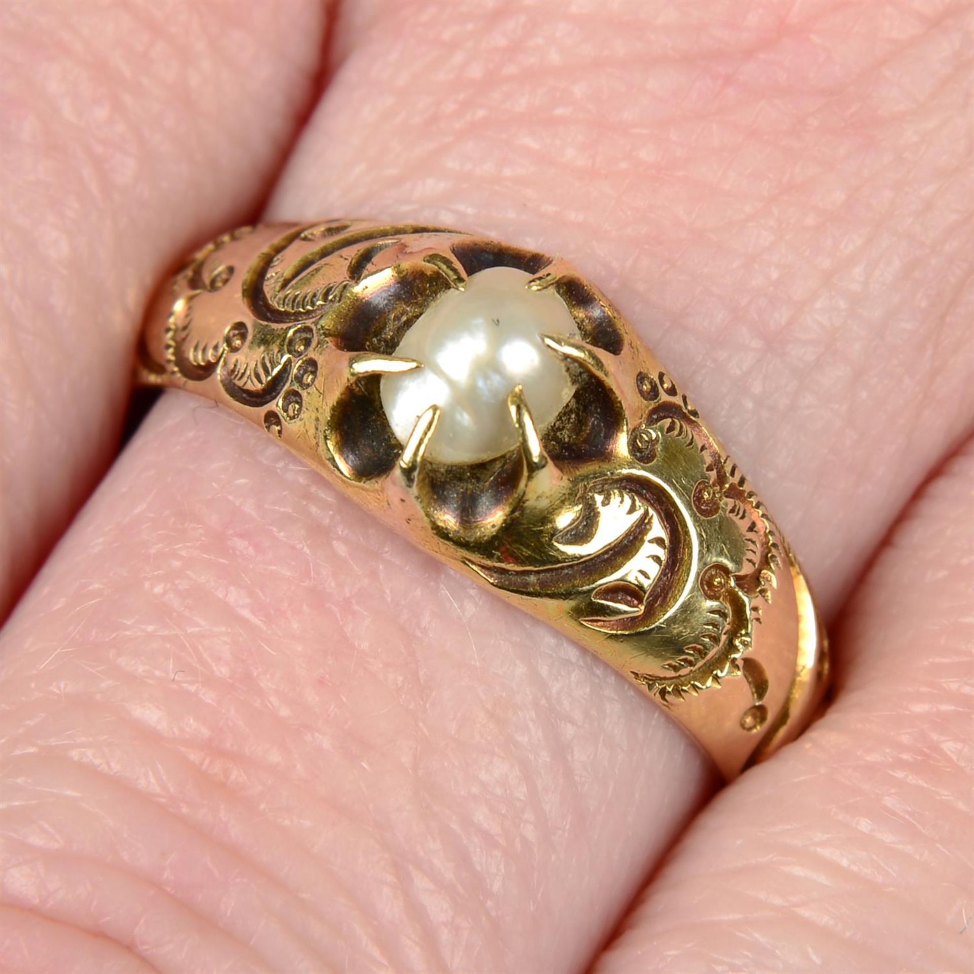 A 19th century gold pearl ring, with foliate engraved shoulders and grooved half-band.