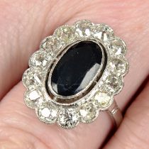 A mid 20th century platinum sapphire and old-cut diamond cluster ring.
