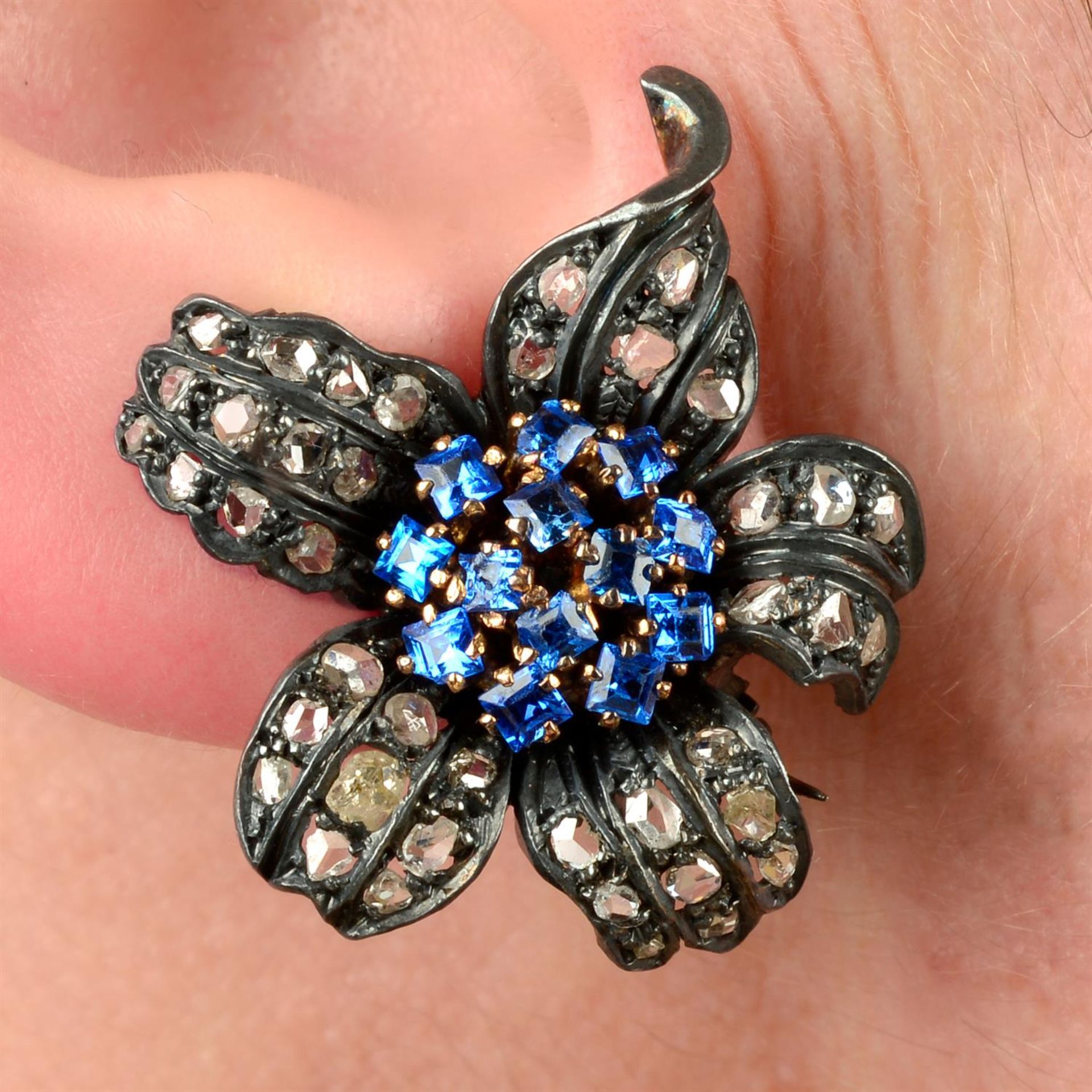 A pair of synthetic sapphire and rose-cut diamond floral earrings/brooches.