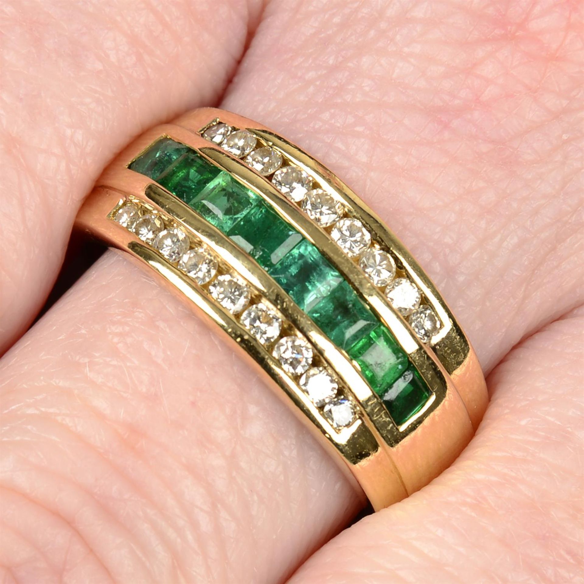 An 18ct gold brilliant-cut diamond and emerald three-row band ring.