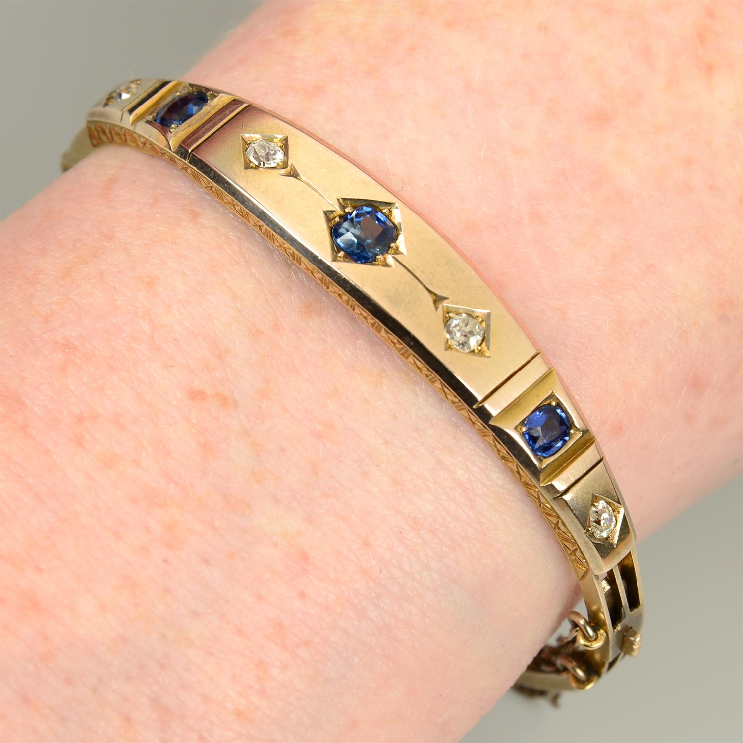 A late 19th century gold sapphire and old-cut diamond hinged bangle.