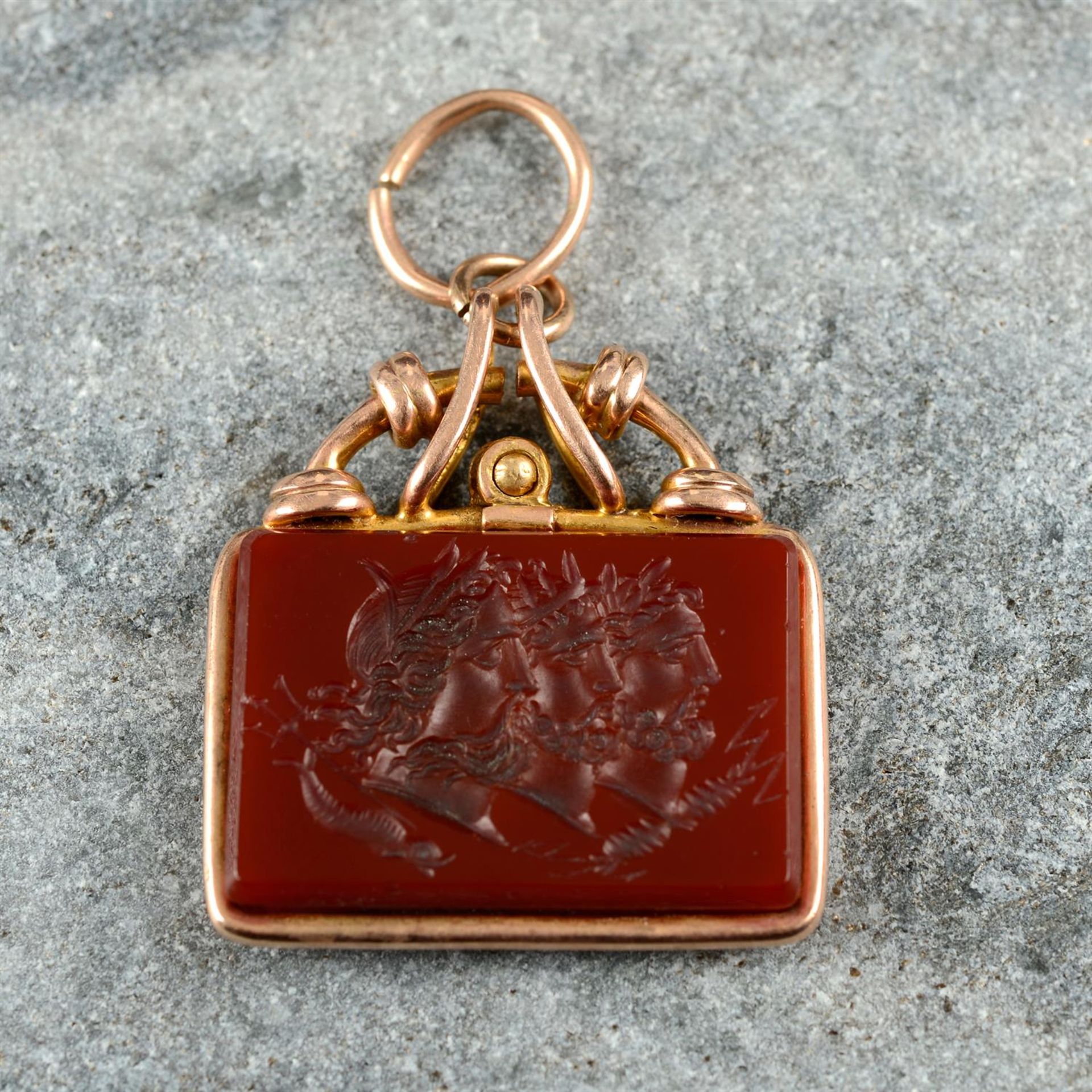 A 19th century gold carnelian intaglio pendant, carved to depict Zeus, Poseidon and Hades in