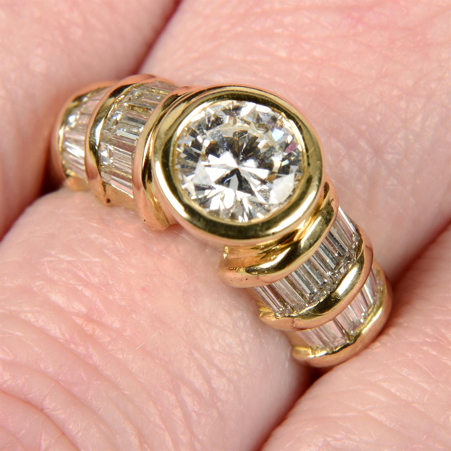 A brilliant-cut diamond dress ring, with baguette-cut diamond shoulders.