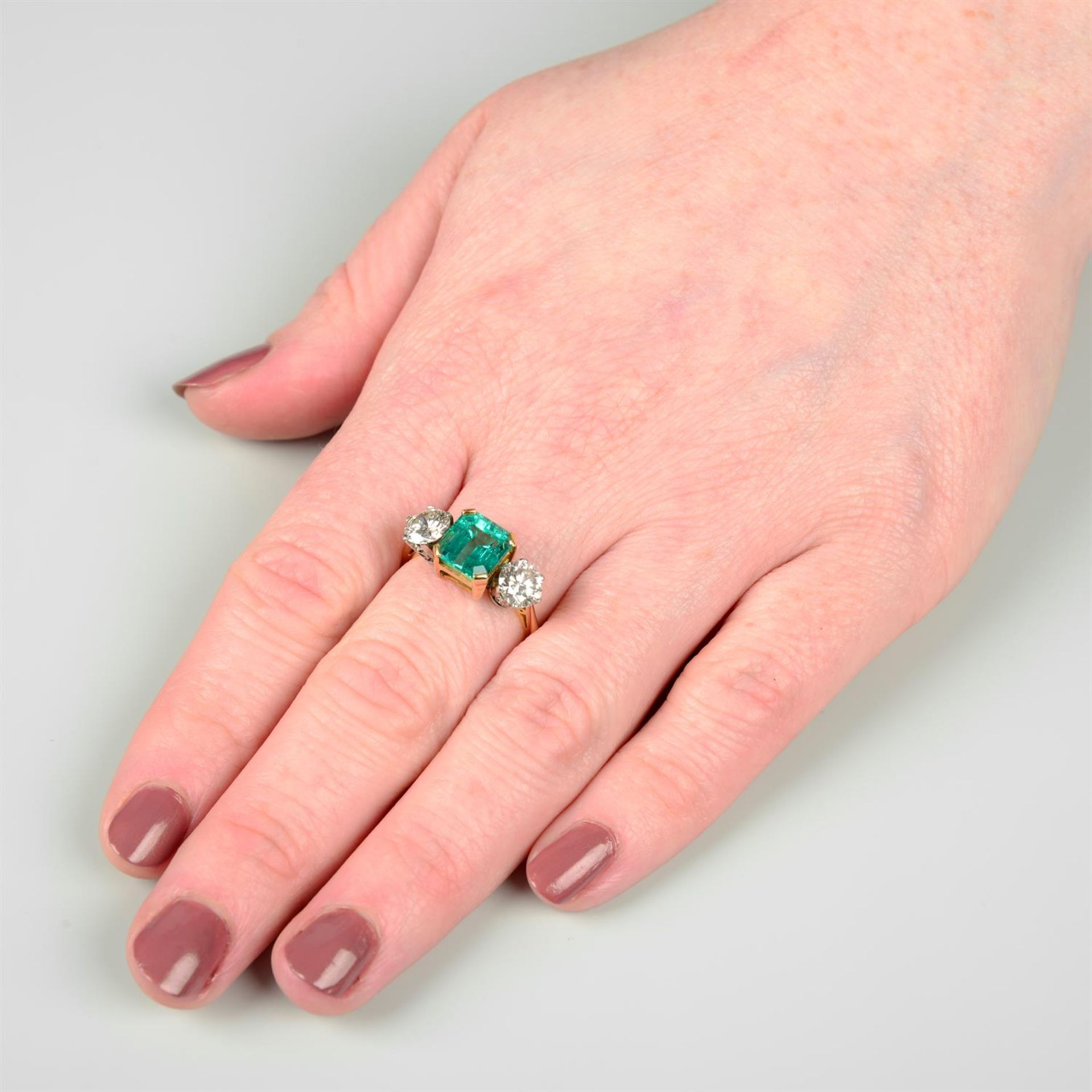 An 18ct gold emerald and brilliant-cut diamond three-stone ring. - Image 6 of 6