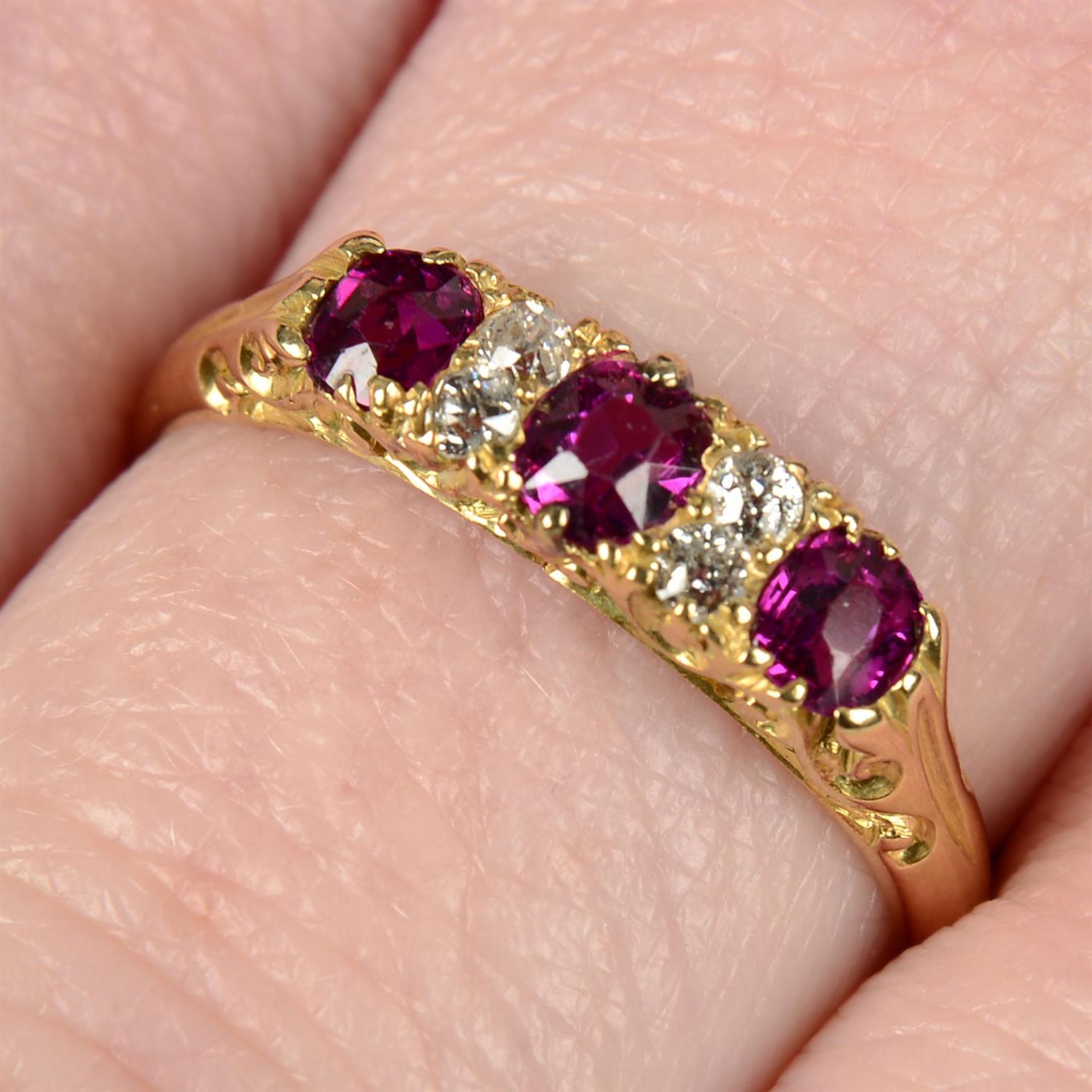 An early 20th century 18ct gold ruby three-stone ring, with old-cut diamond spacers.