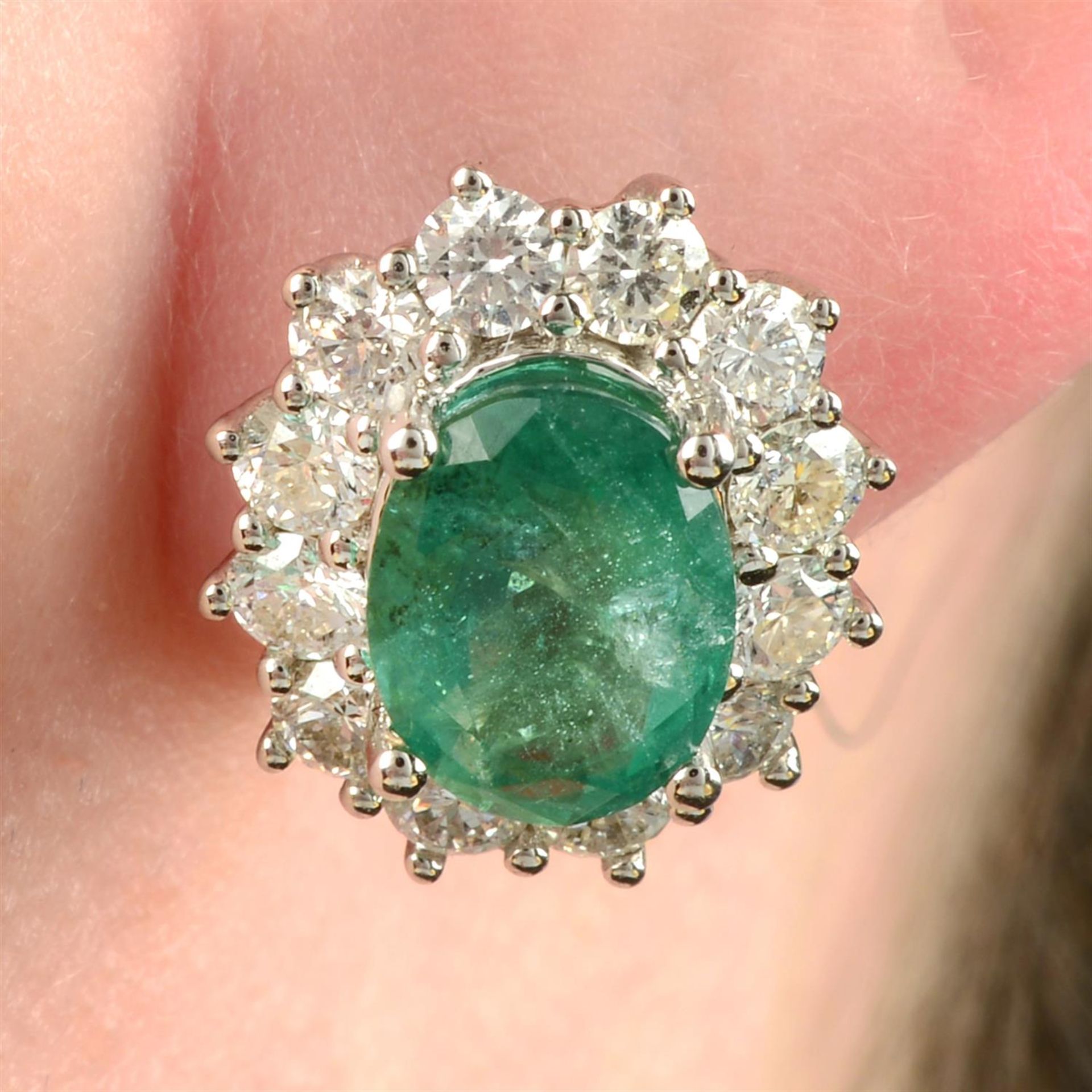 A pair of 18ct gold emerald and brilliant-cut diamond cluster earrings.