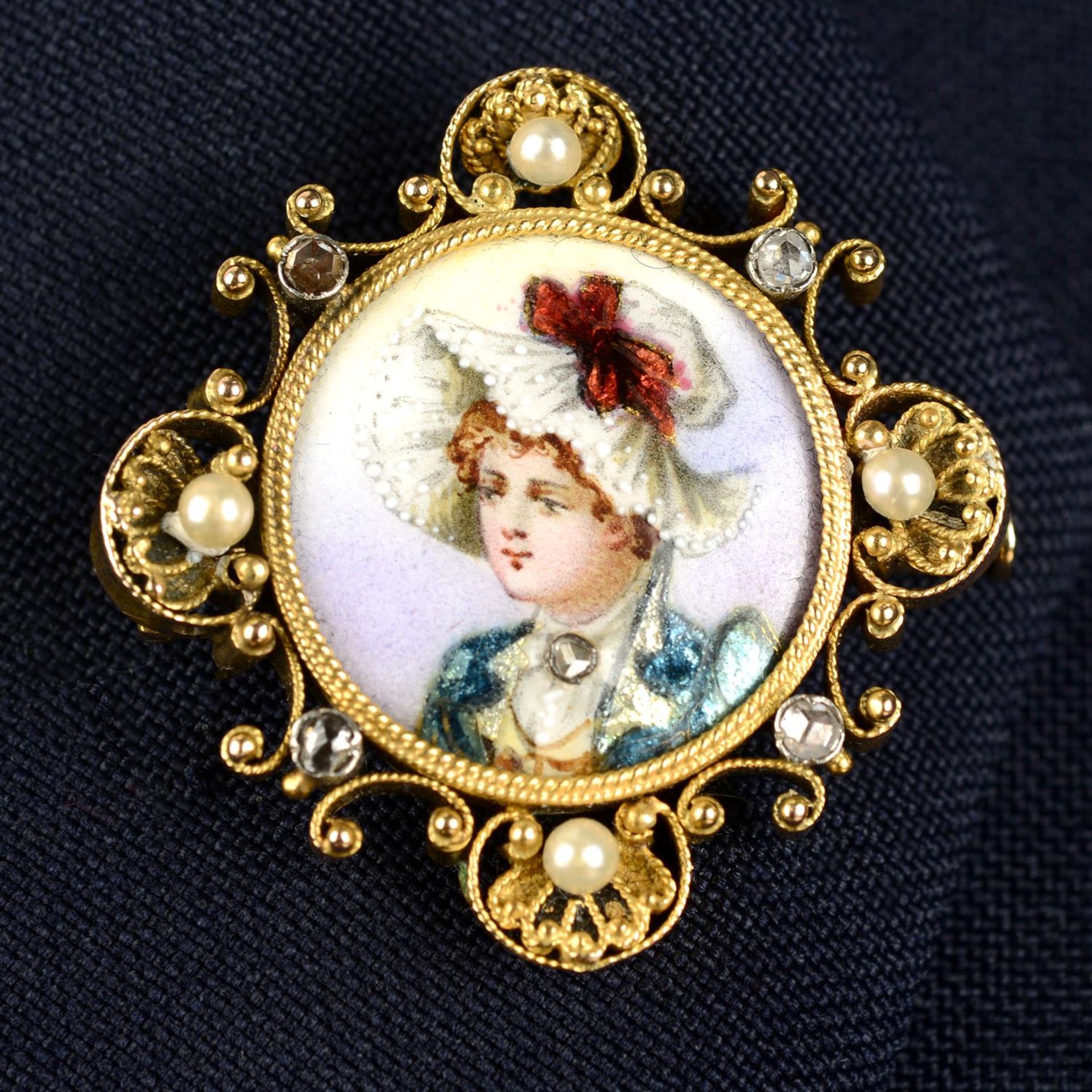 An early 20th century gold mounted enamel brooch depicting a woman, to a shell and scroll