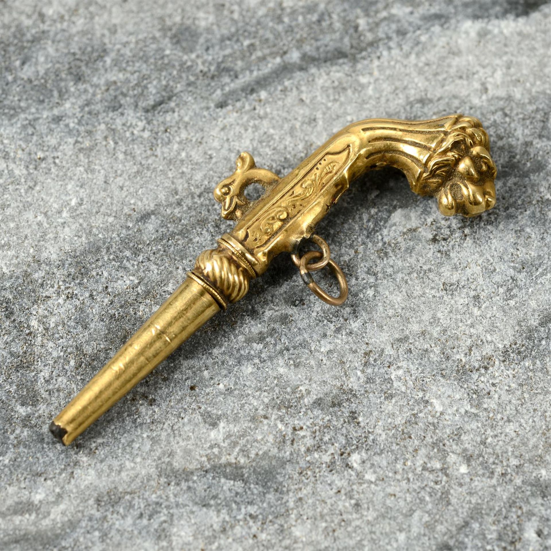 A 19th century 18ct gold watch key, modelled as a pistol with lion head grip.