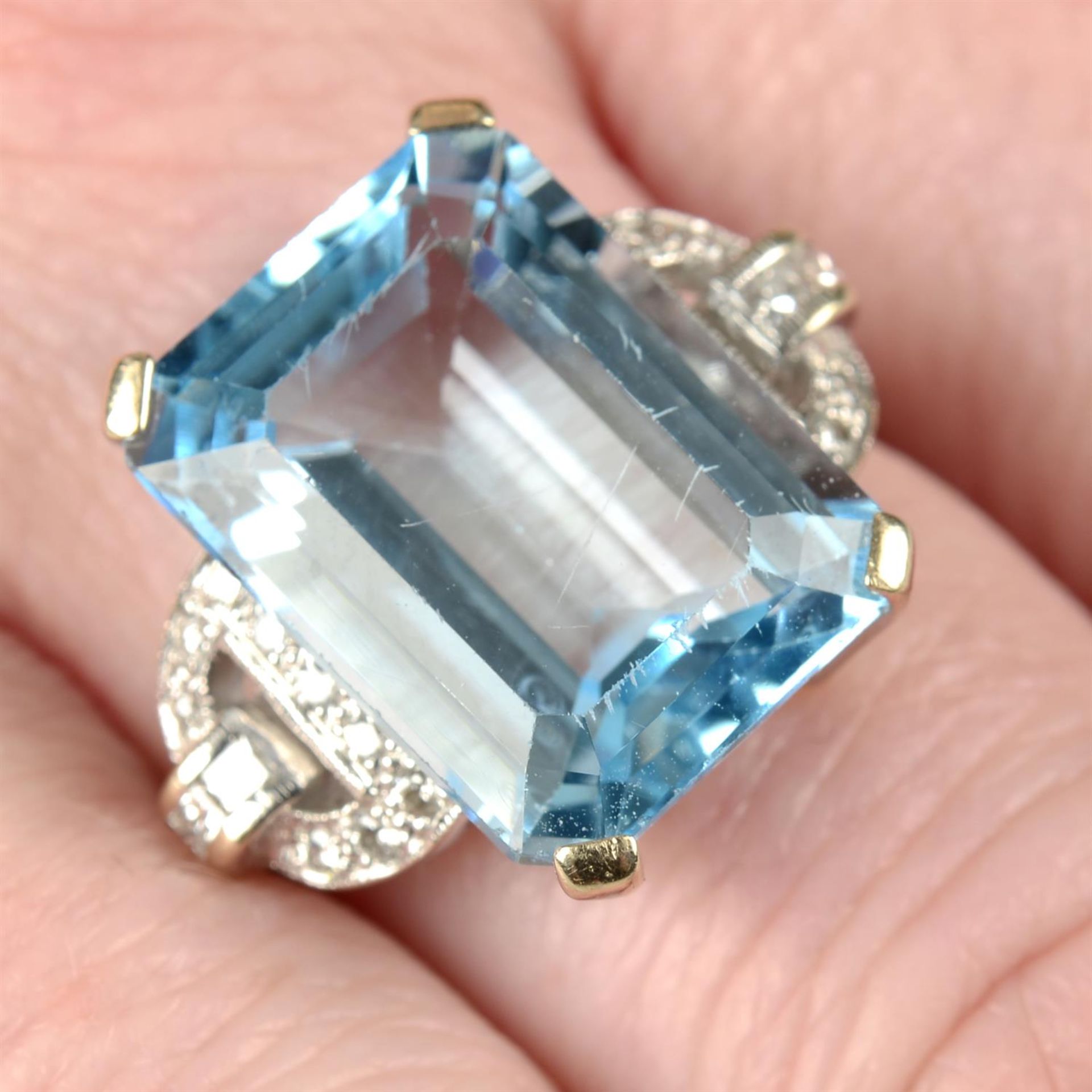 An 18ct gold blue topaz single-stone ring, with vari-cut diamond geometric sides.