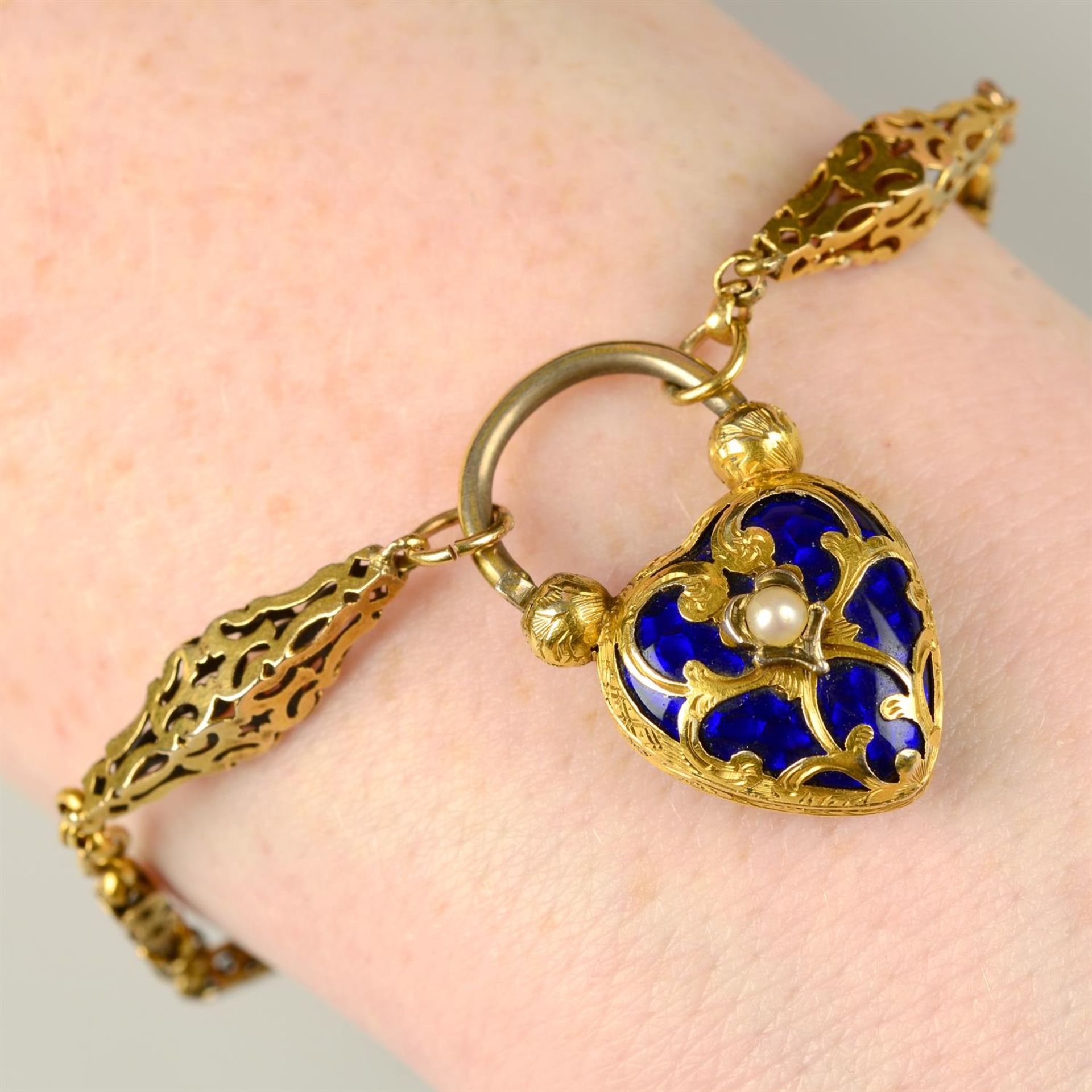 A Victorian gold pierced bracelet, with split pearl and blue enamel locket heart clasp.