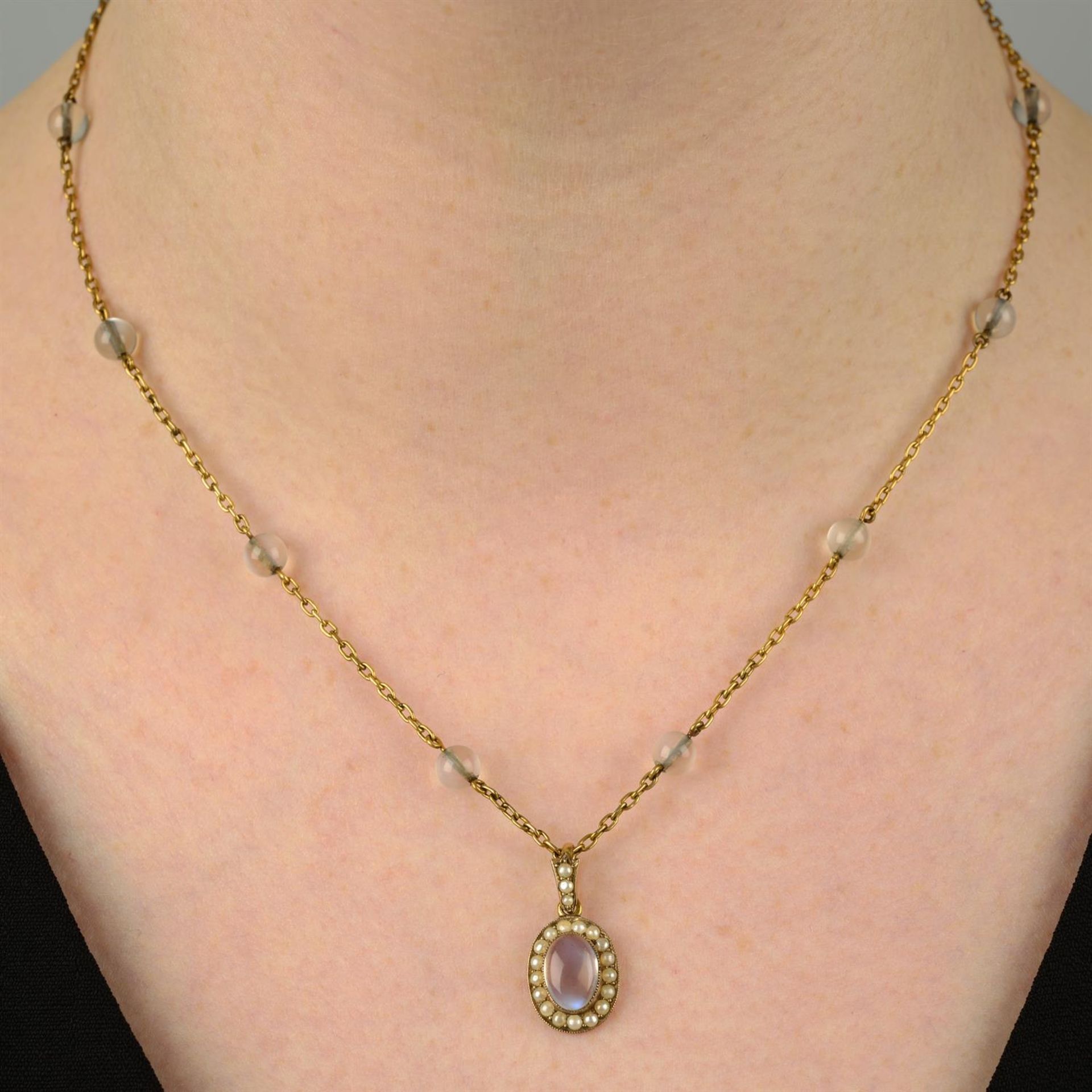 An early 20th century 9ct gold moonstone split pearl pendant, suspended from a moonstone bead