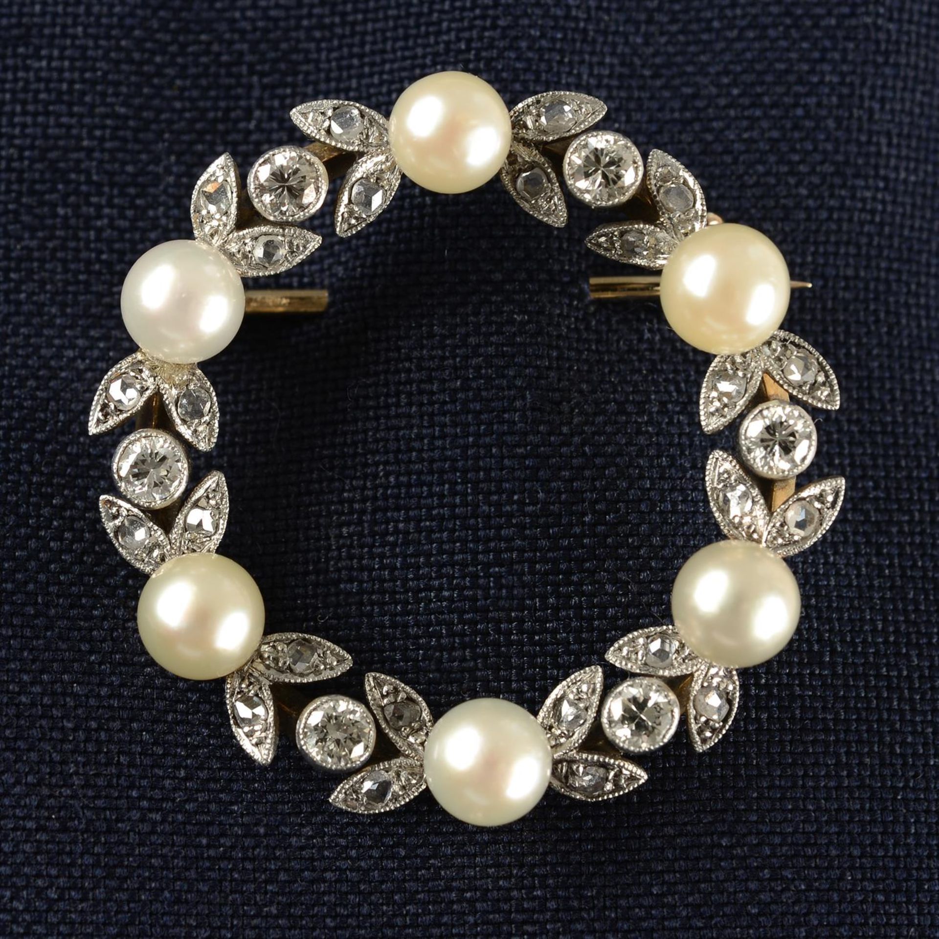 A mid 20th century platinum and 14ct gold cultured pearl and vari-cut diamond wreath brooch.