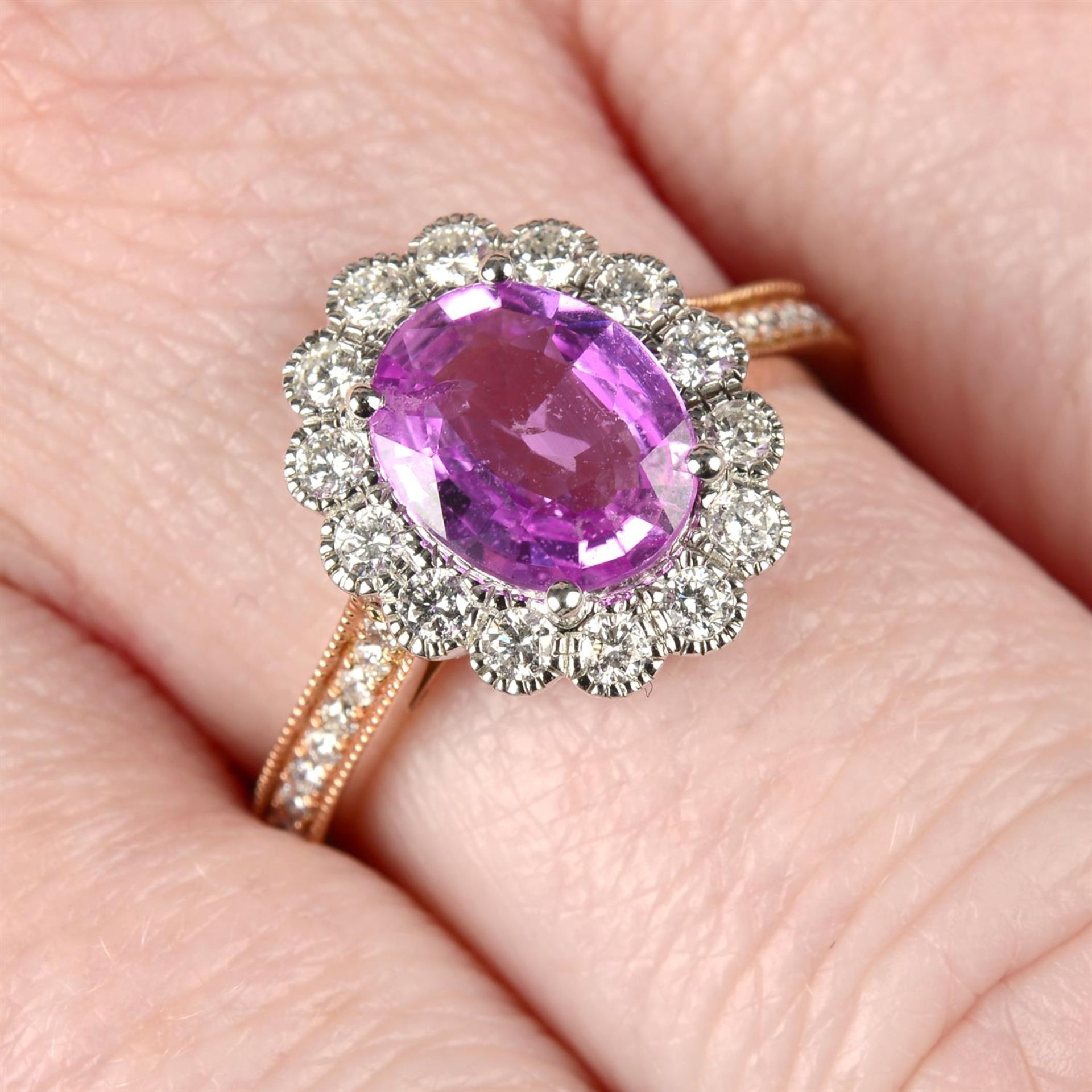 An 18ct gold pink sapphire and brilliant-cut diamond cluster ring.