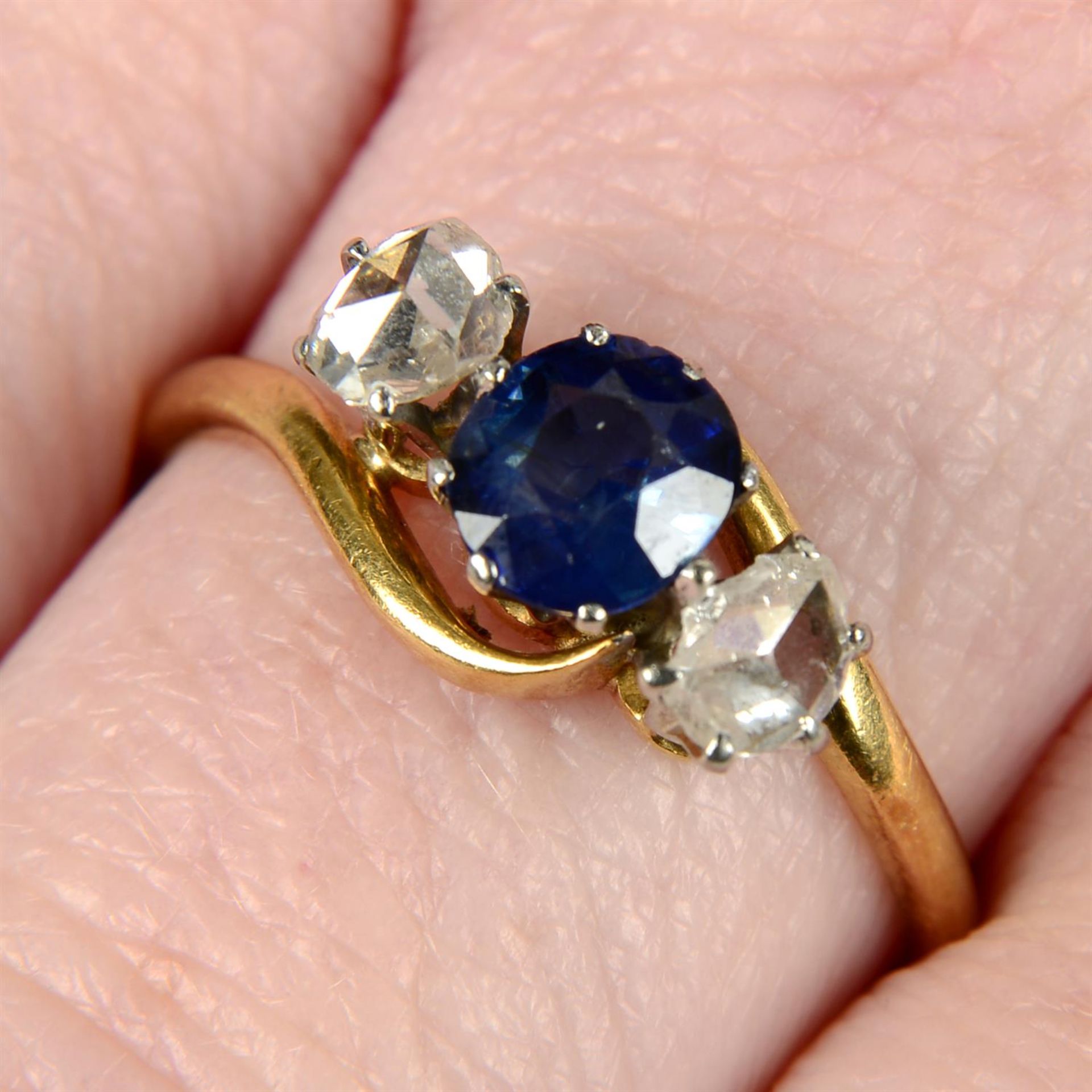 An early 20th century 18ct gold sapphire and rose-cut diamond crossover ring.