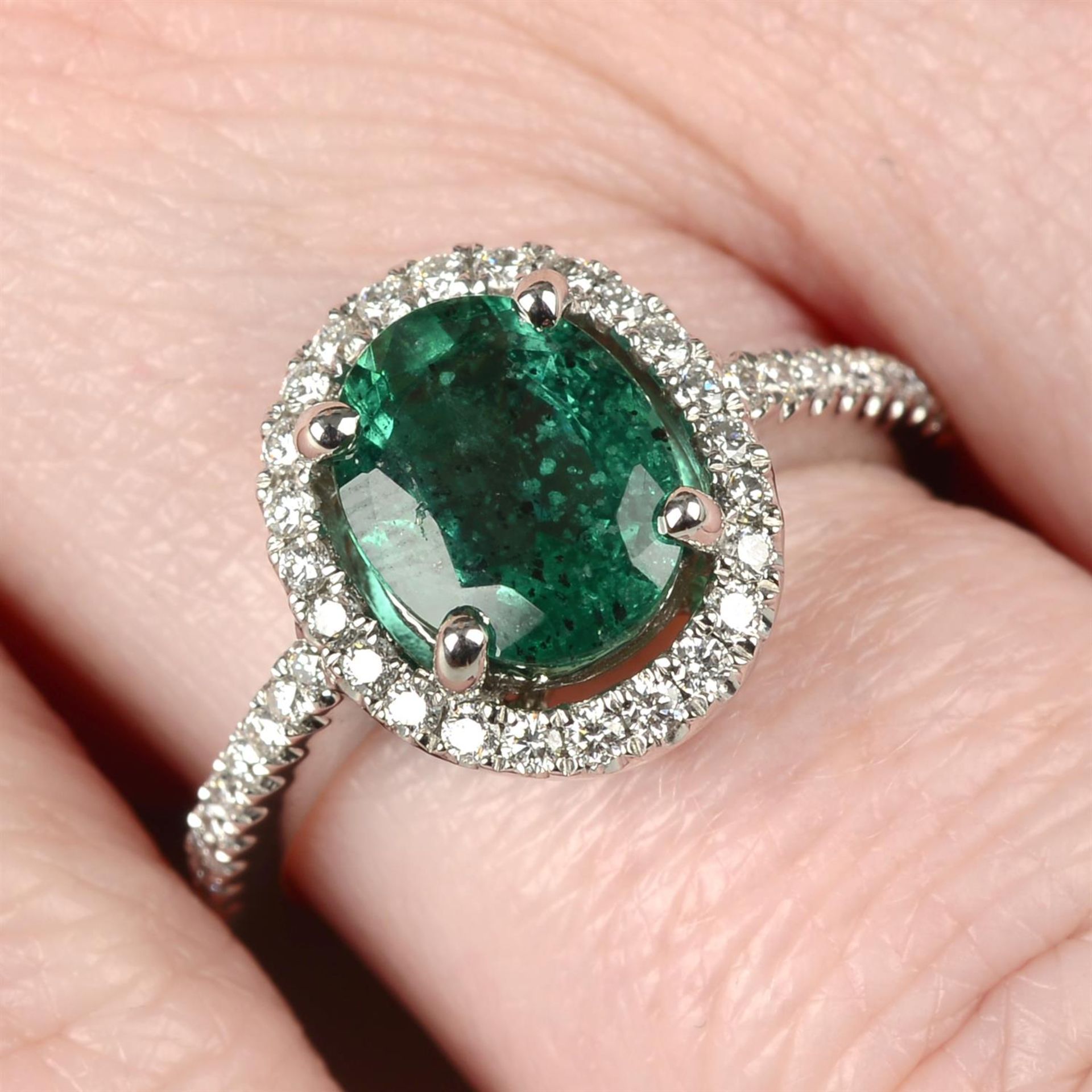 An emerald and brilliant-cut diamond dress ring.