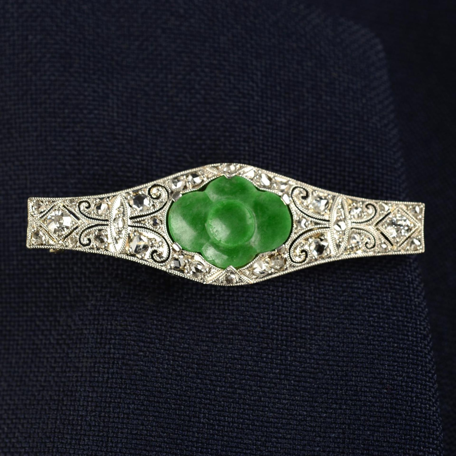 An Art Deco platinum and 18ct gold, carved jade and vari-cut diamond pierced brooch.