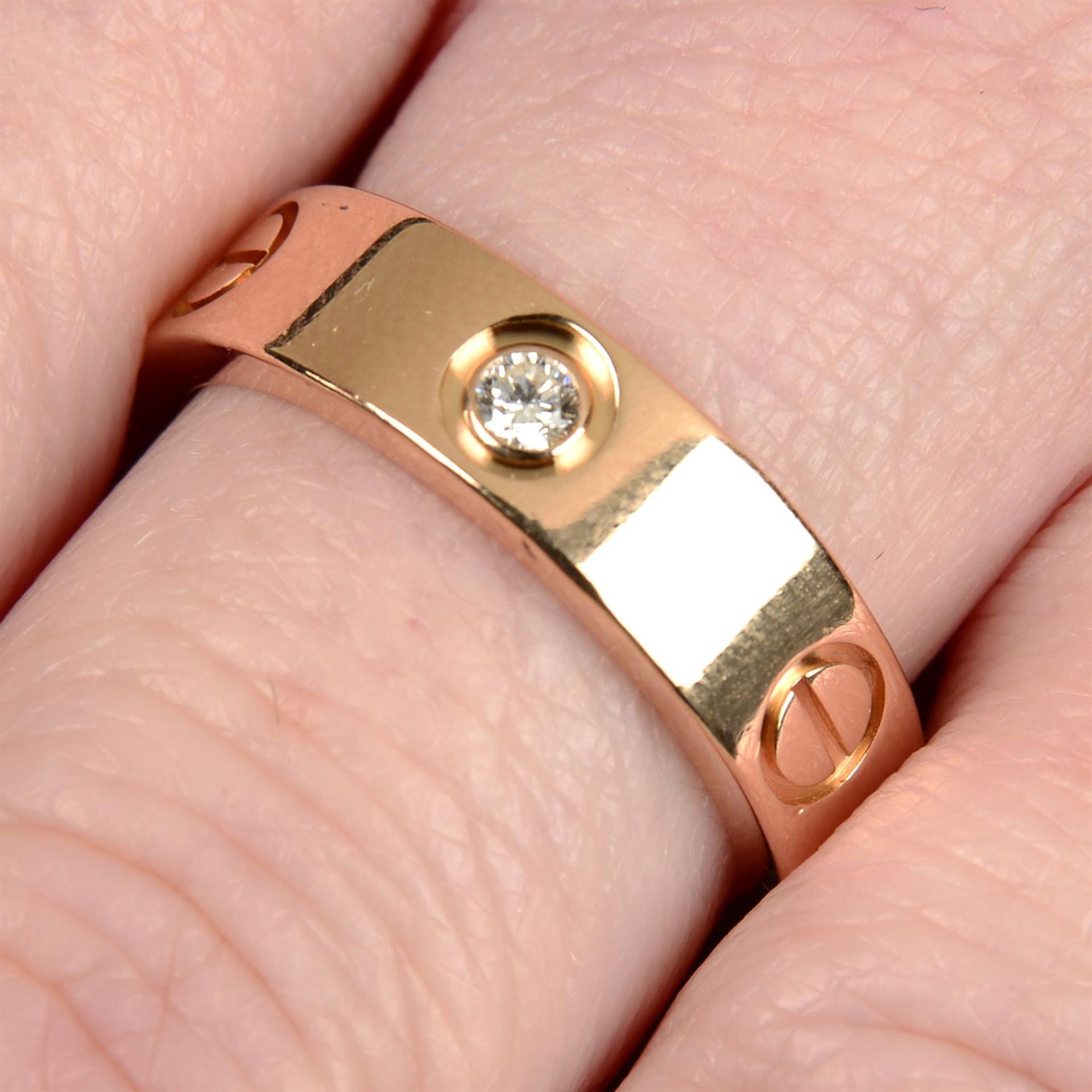 An 18ct gold alternating brilliant-cut diamond and screw motif 'Love' ring, by Cartier.