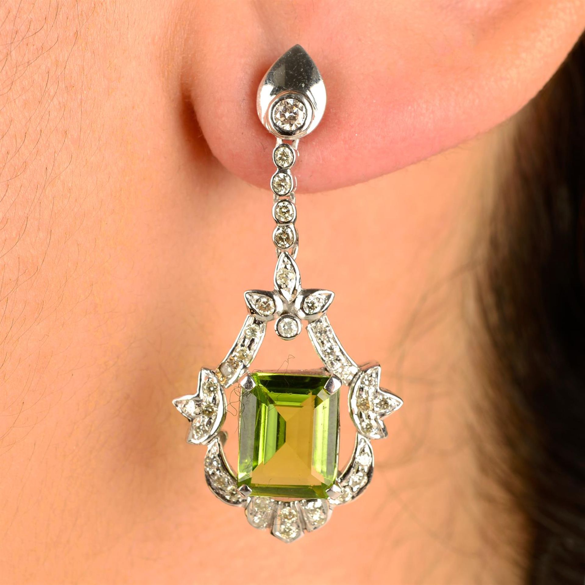 A pair of peridot and diamond drop earrings.