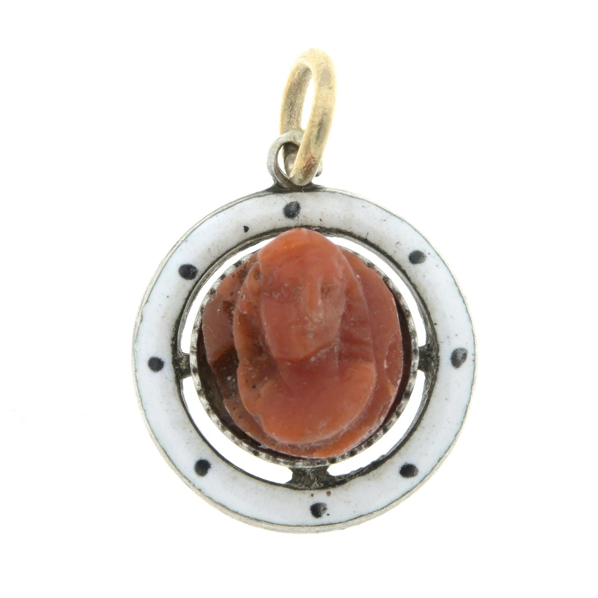 An early 20th century carved coral and enamel bi-colour pendant.
