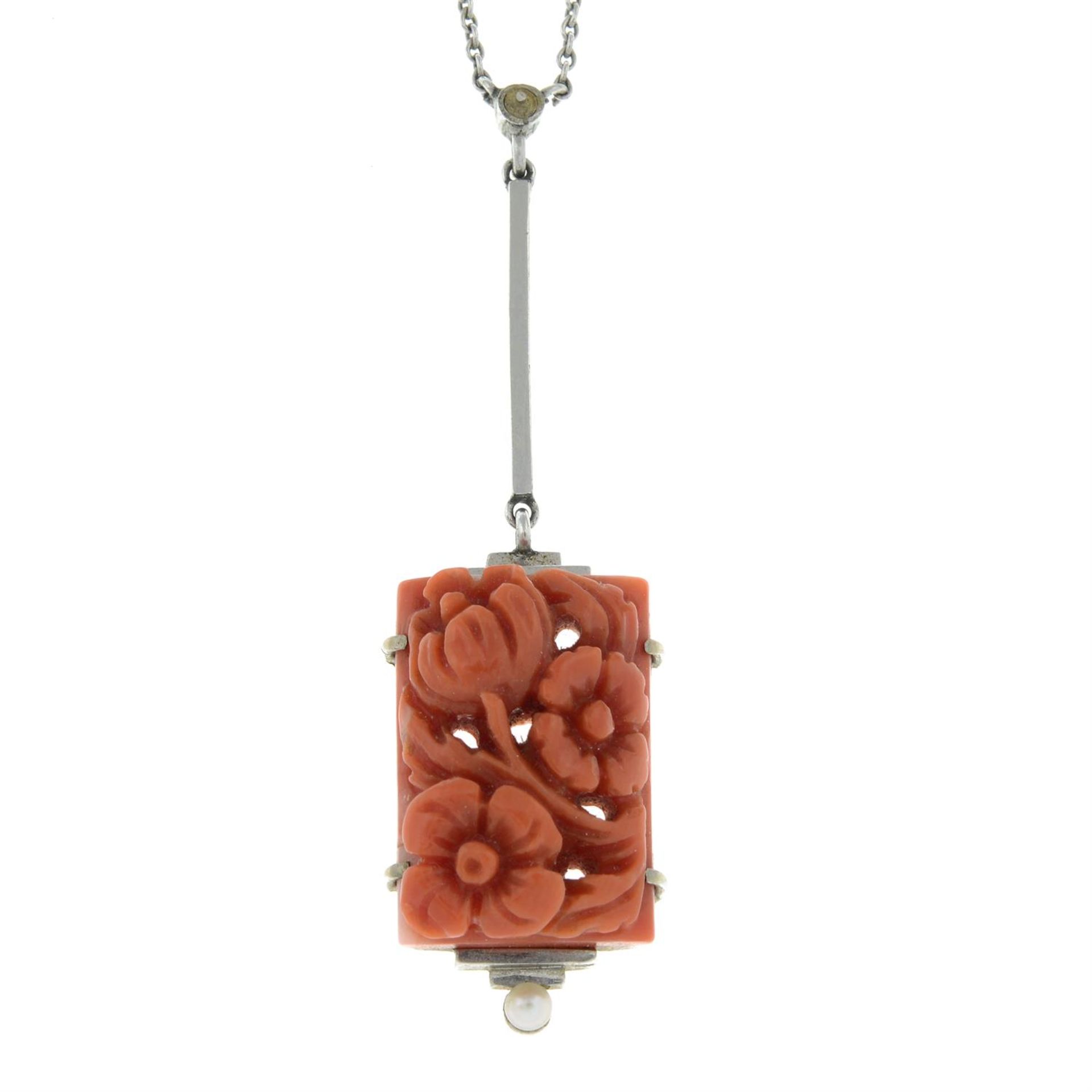 An early to mid 20th century 9ct gold carved coral and seed pearl pendant, on integral chain.