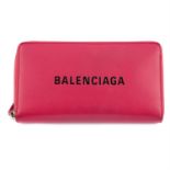 BALENCIAGA – a pink leather zippy wallet.