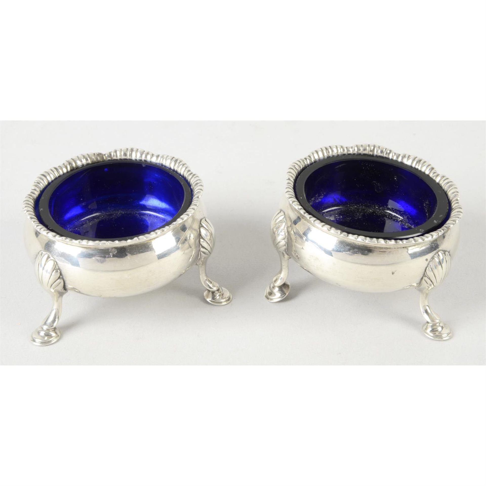 A pair of early George III silver cauldron open salts, with blue glass liners.