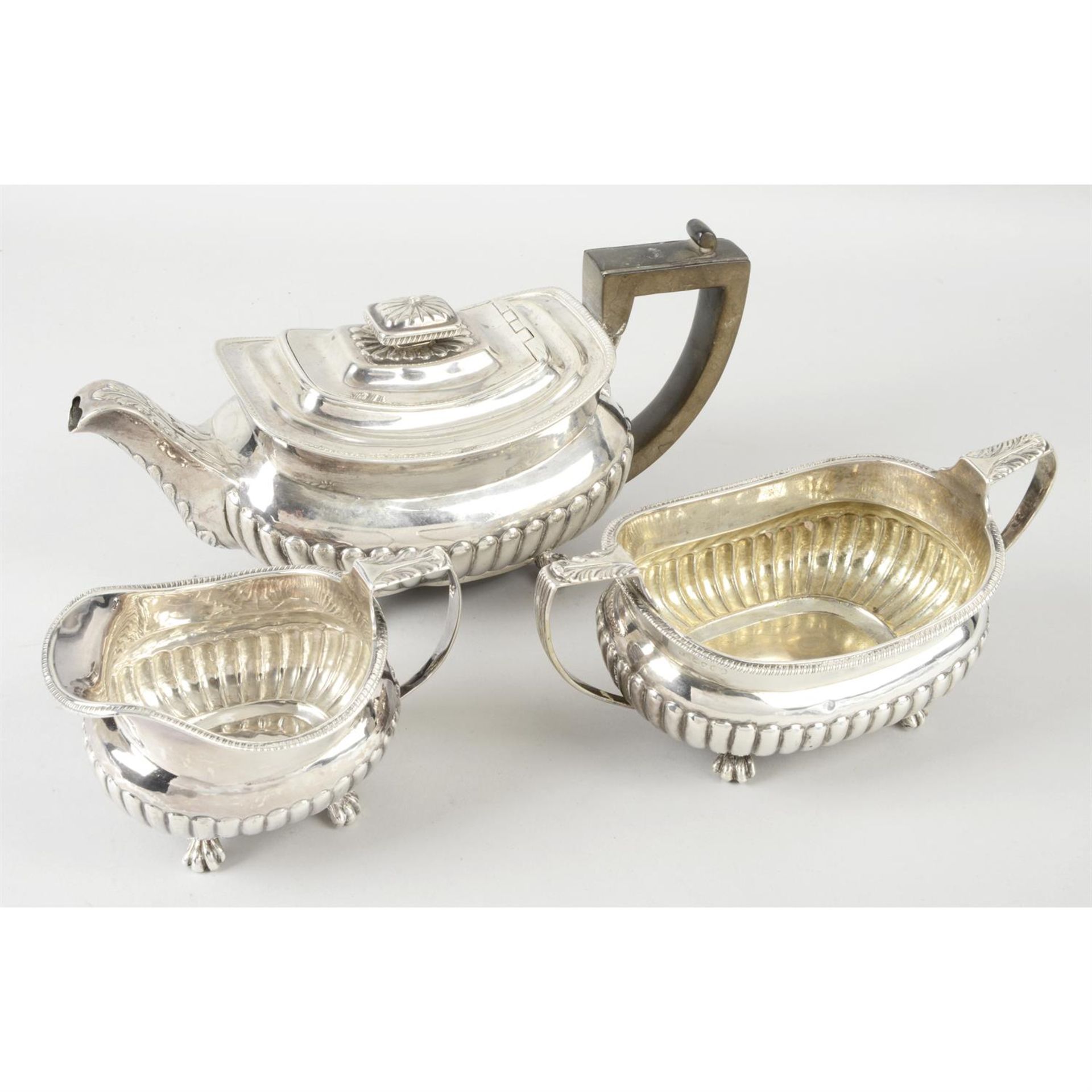 A George III silver teapot; together with a George IV twin-handled sugar bowl & cream jug of