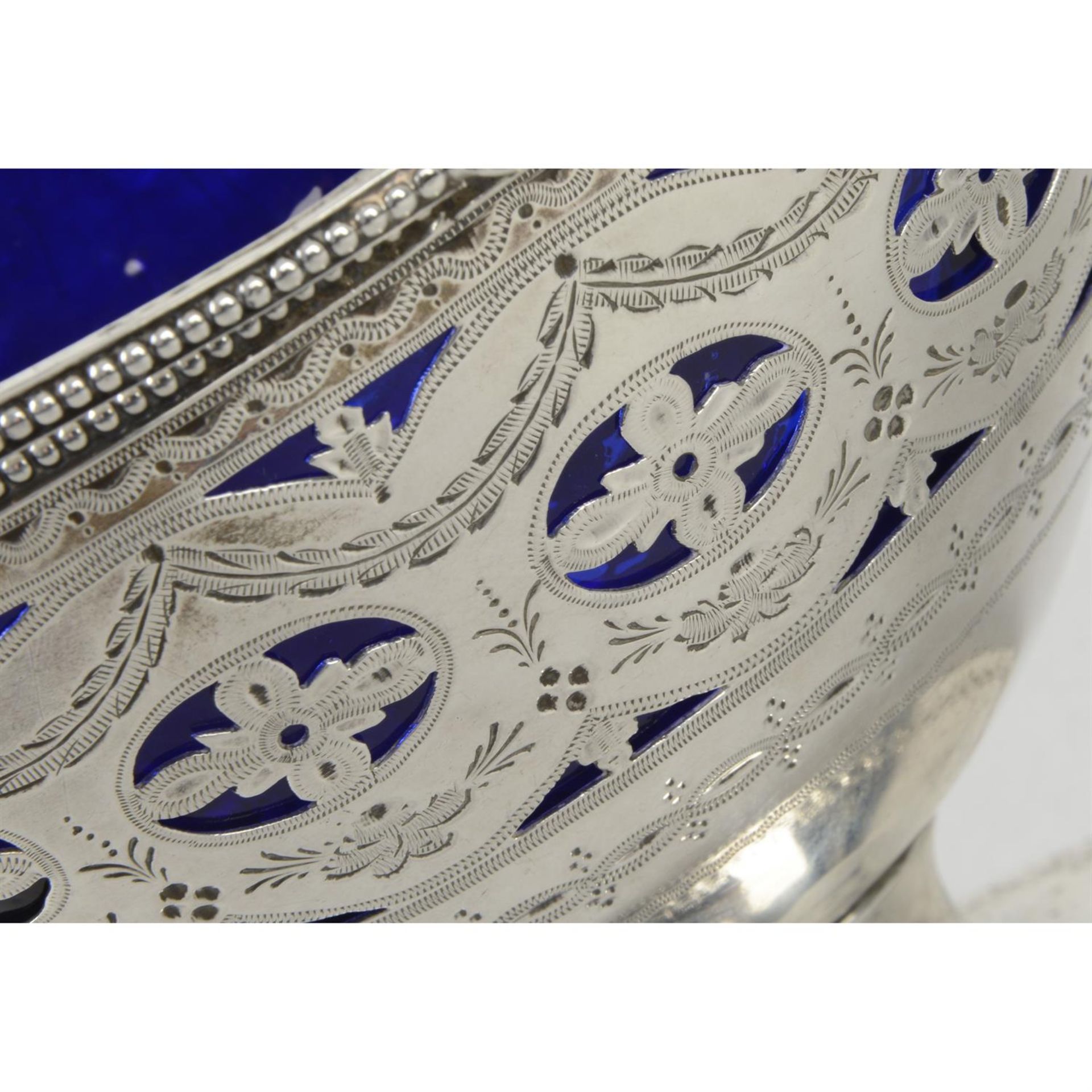 A George III silver swing-handled sugar basket with blue glass liner. - Image 2 of 3