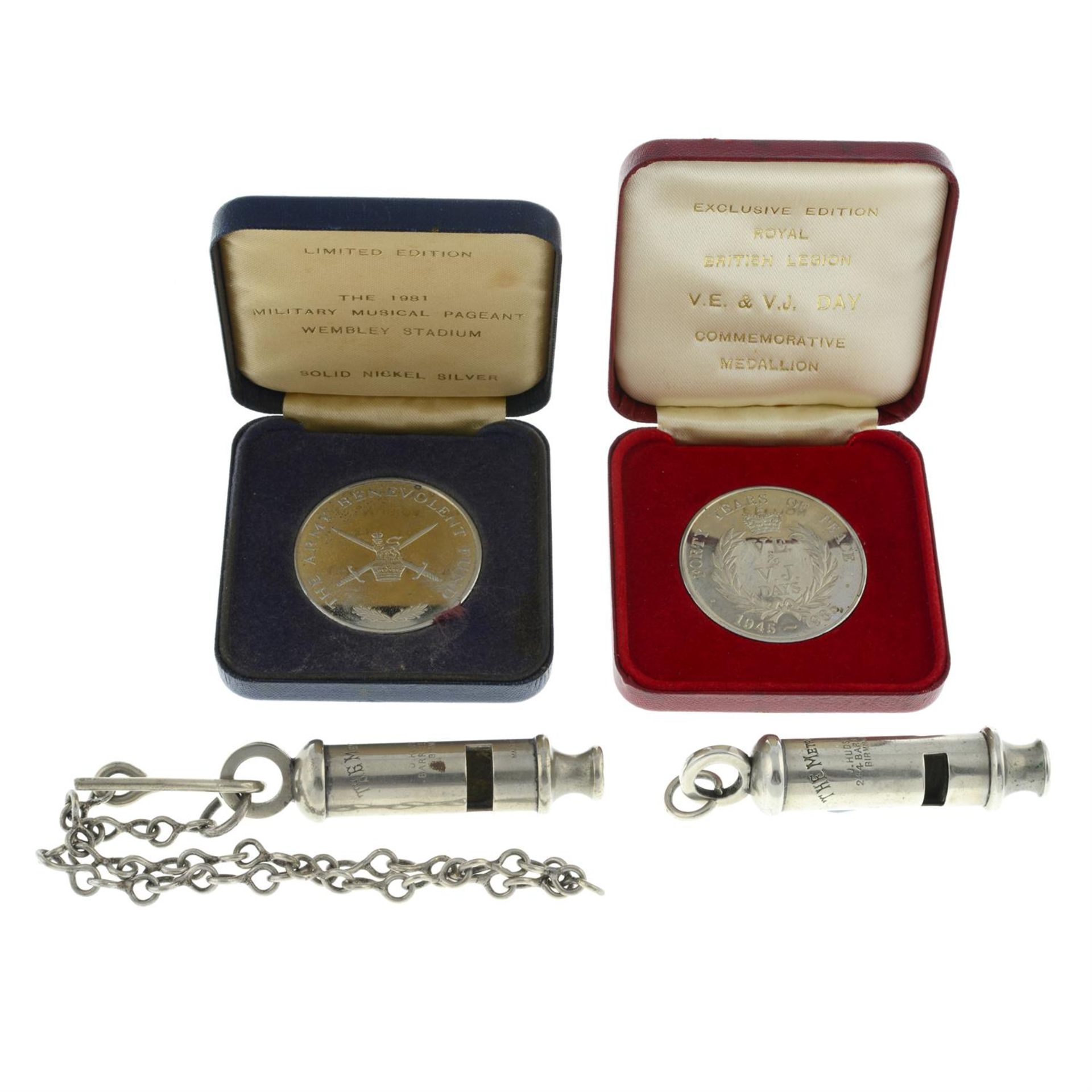 Two Metropolitan whistles; together with two commemorative medallions. (4).