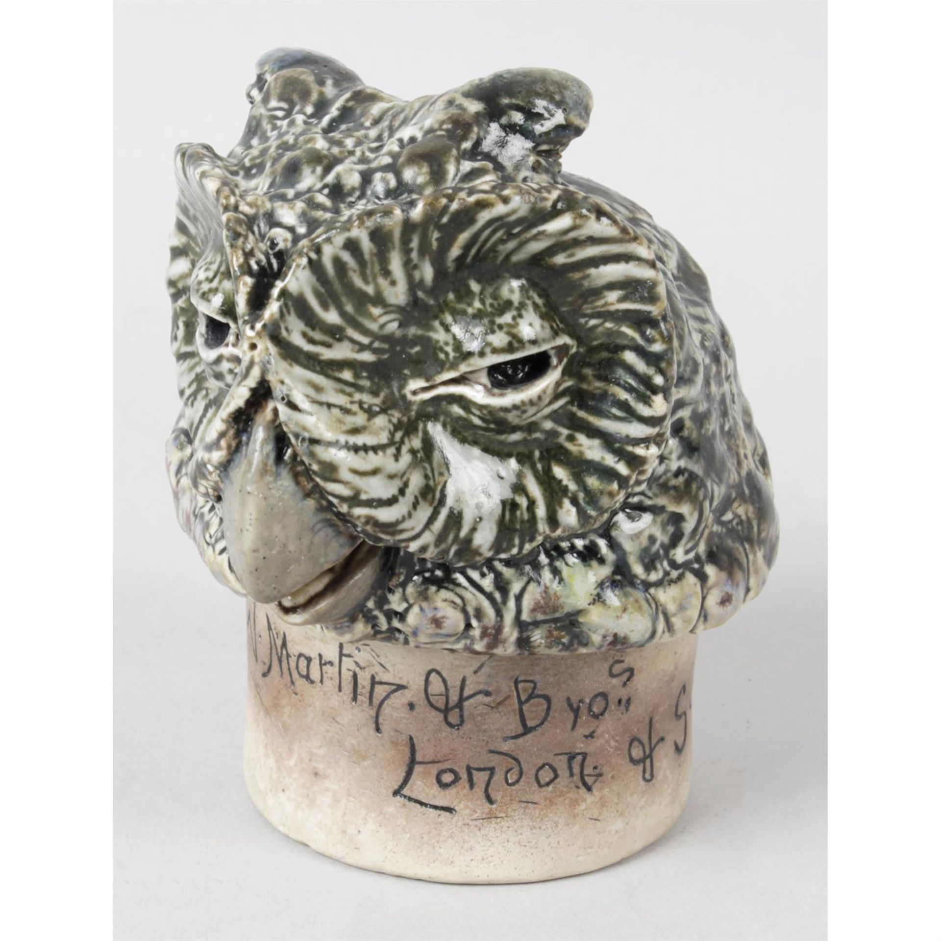 A Martin Brothers pottery jar cover modelled as the head of an owl.