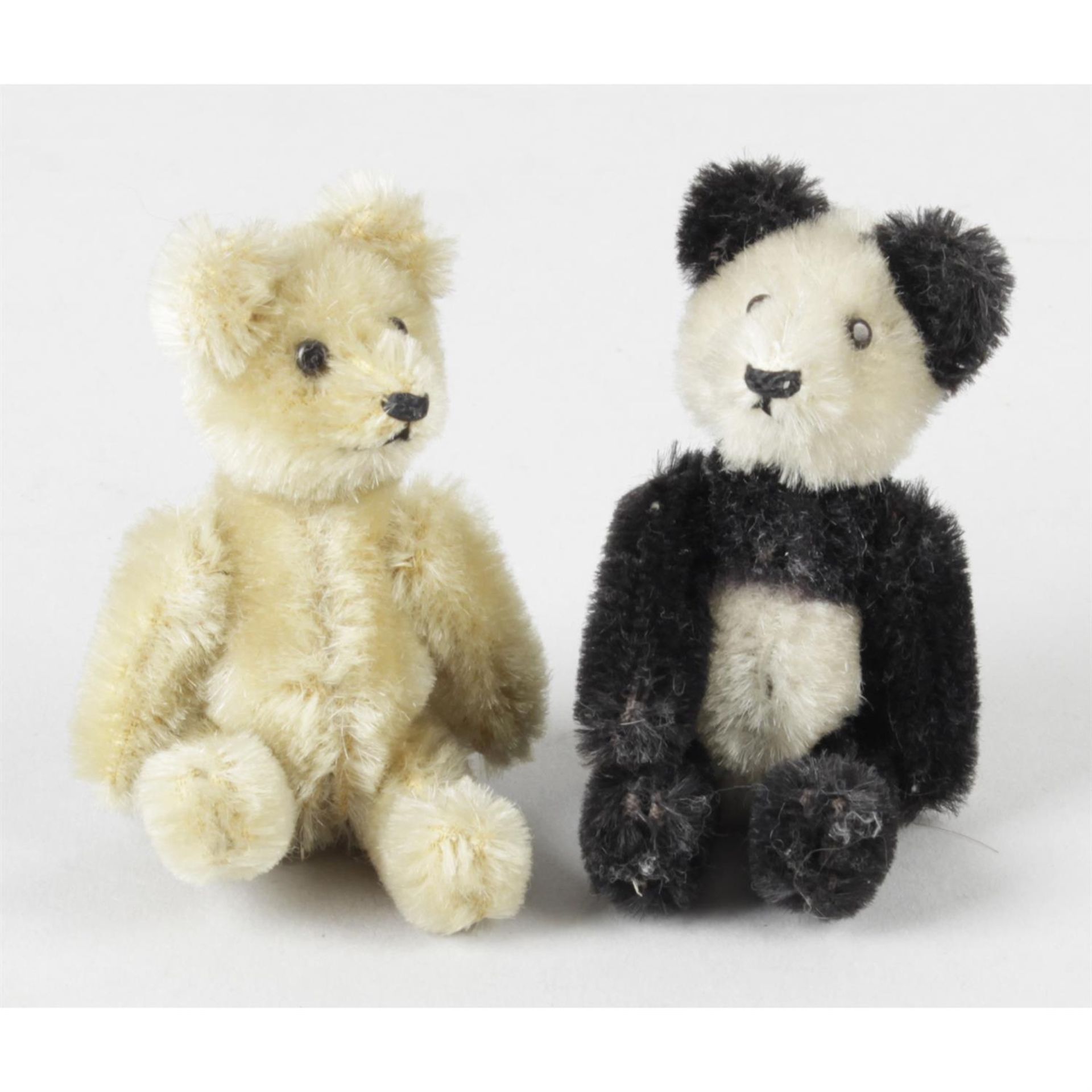 A mid twentieth century Schuco miniature panda bear, together with a similar gold plush teddy bear.