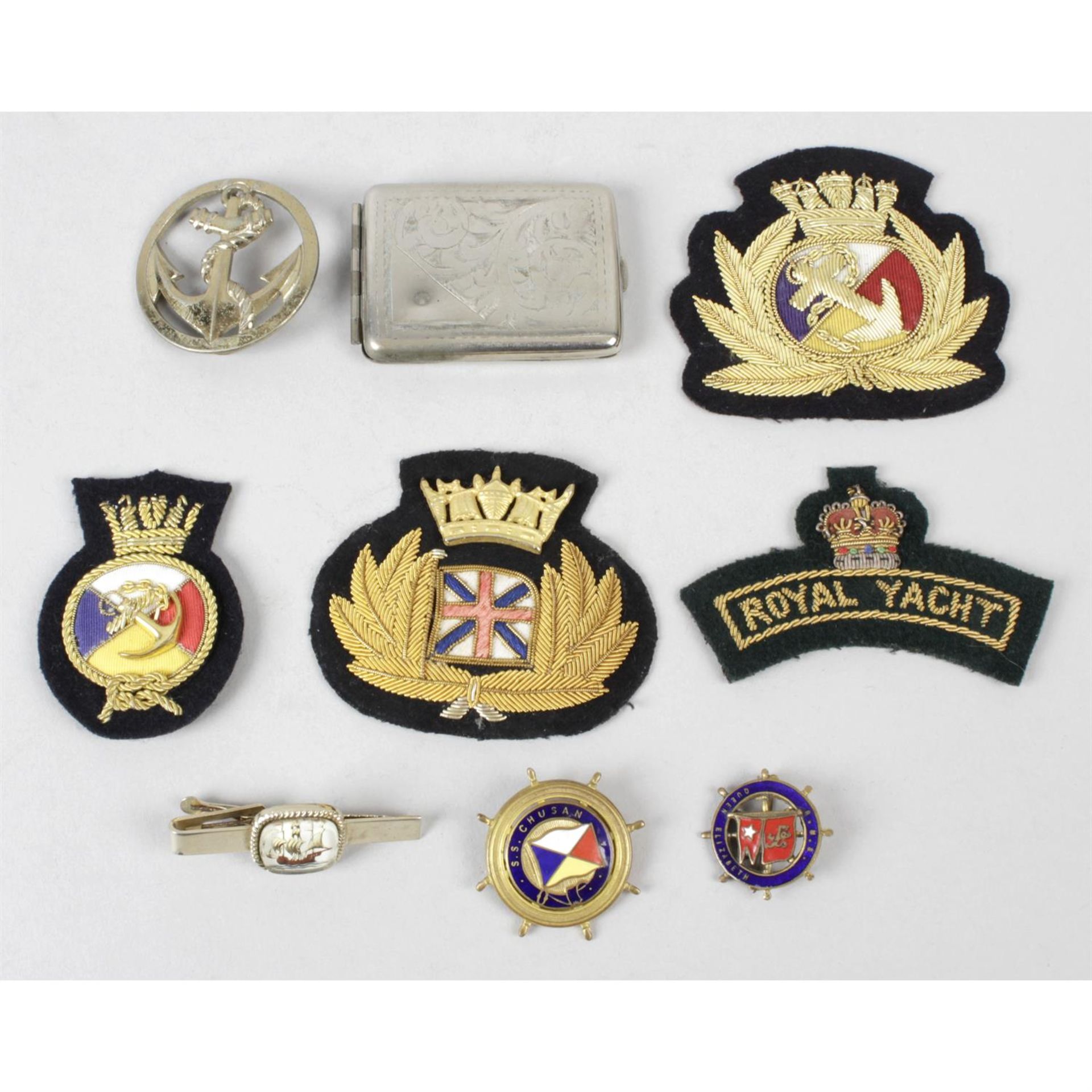 A selection of assorted nautical items, to include badges, a vesta case, etc.