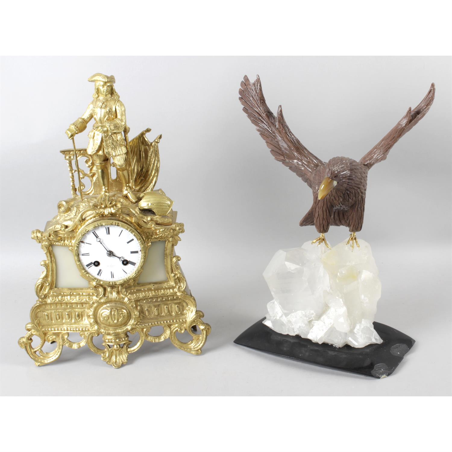A 19th century gilt spelter cased mantel clock, together with a carved hardstone study of an eagle.