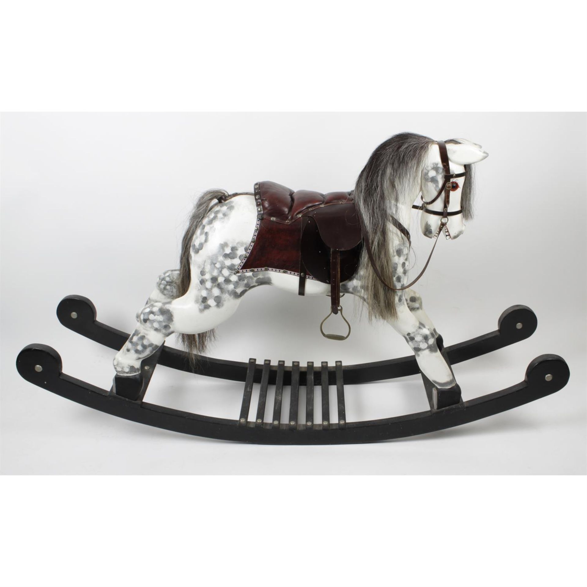 A large modern carved and painted wooden 'dapple grey' rocking horse.