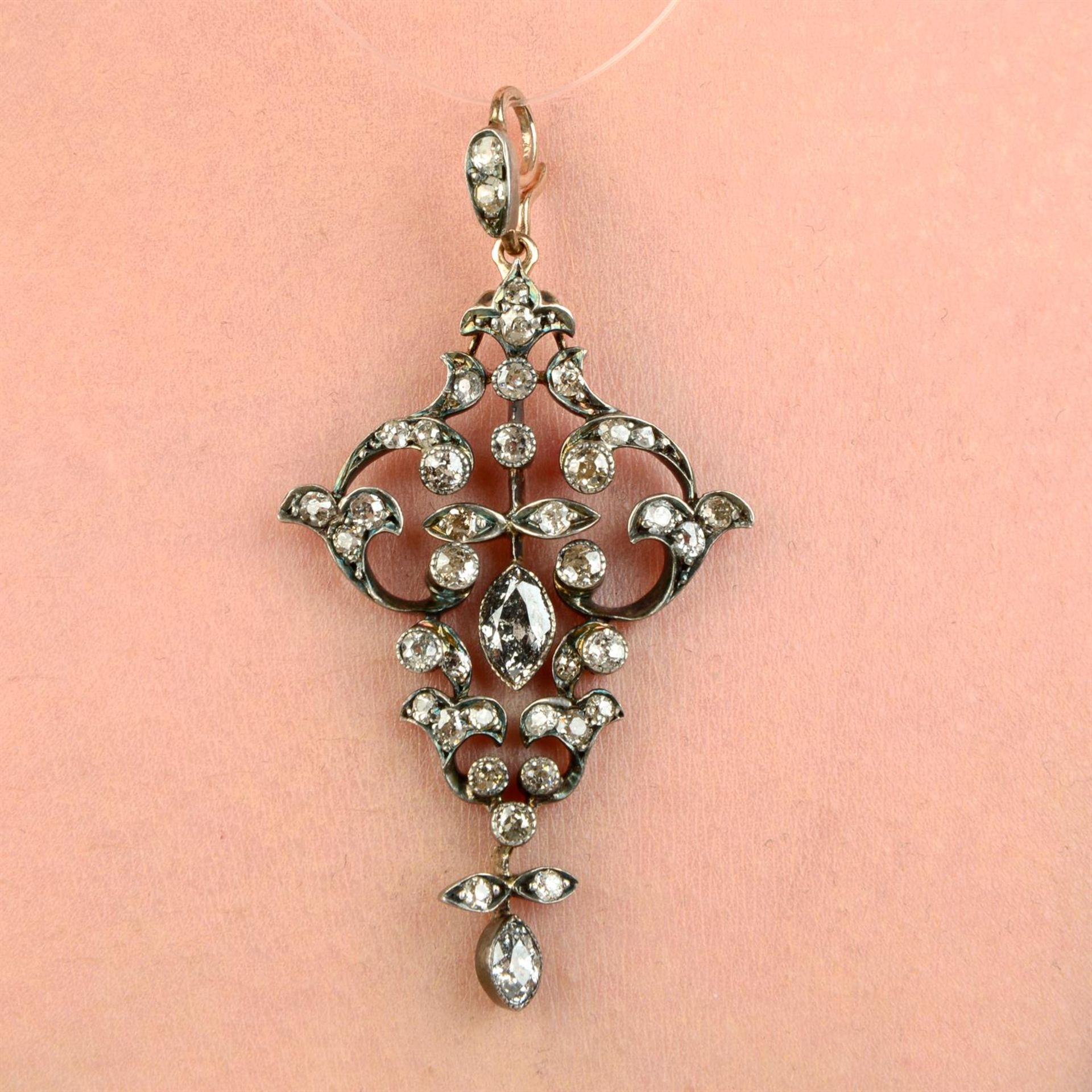 A late 19th century silver and gold old-cut and marquise-shape diamond scrolling foliate pendant.