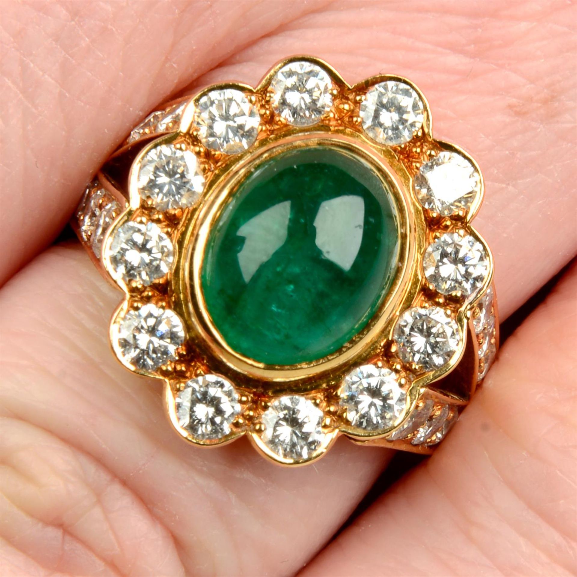 An 18ct gold emerald cabochon and brilliant-cut diamond cluster ring.