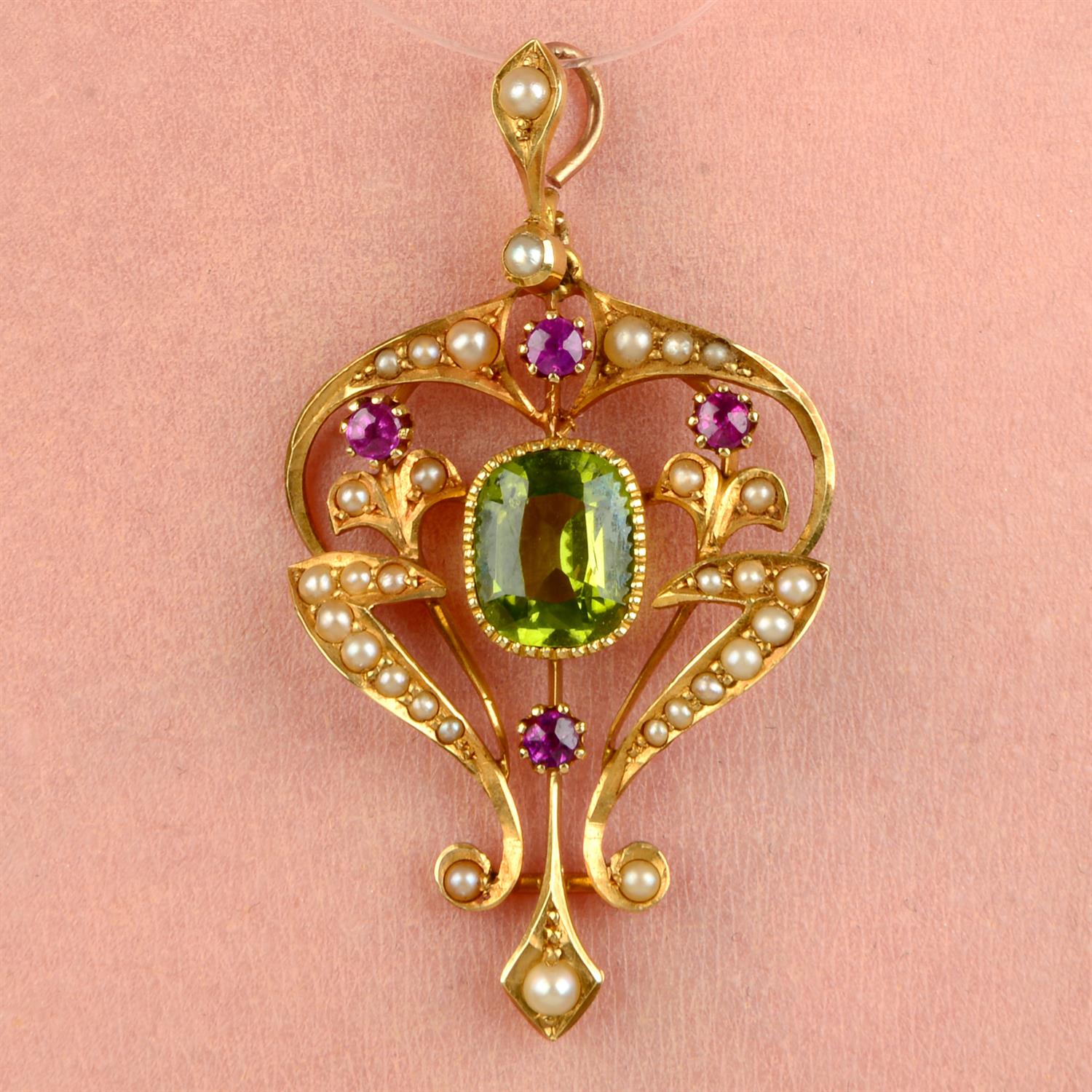 An Edwardian 15ct gold peridot, ruby and split pearl pendant.