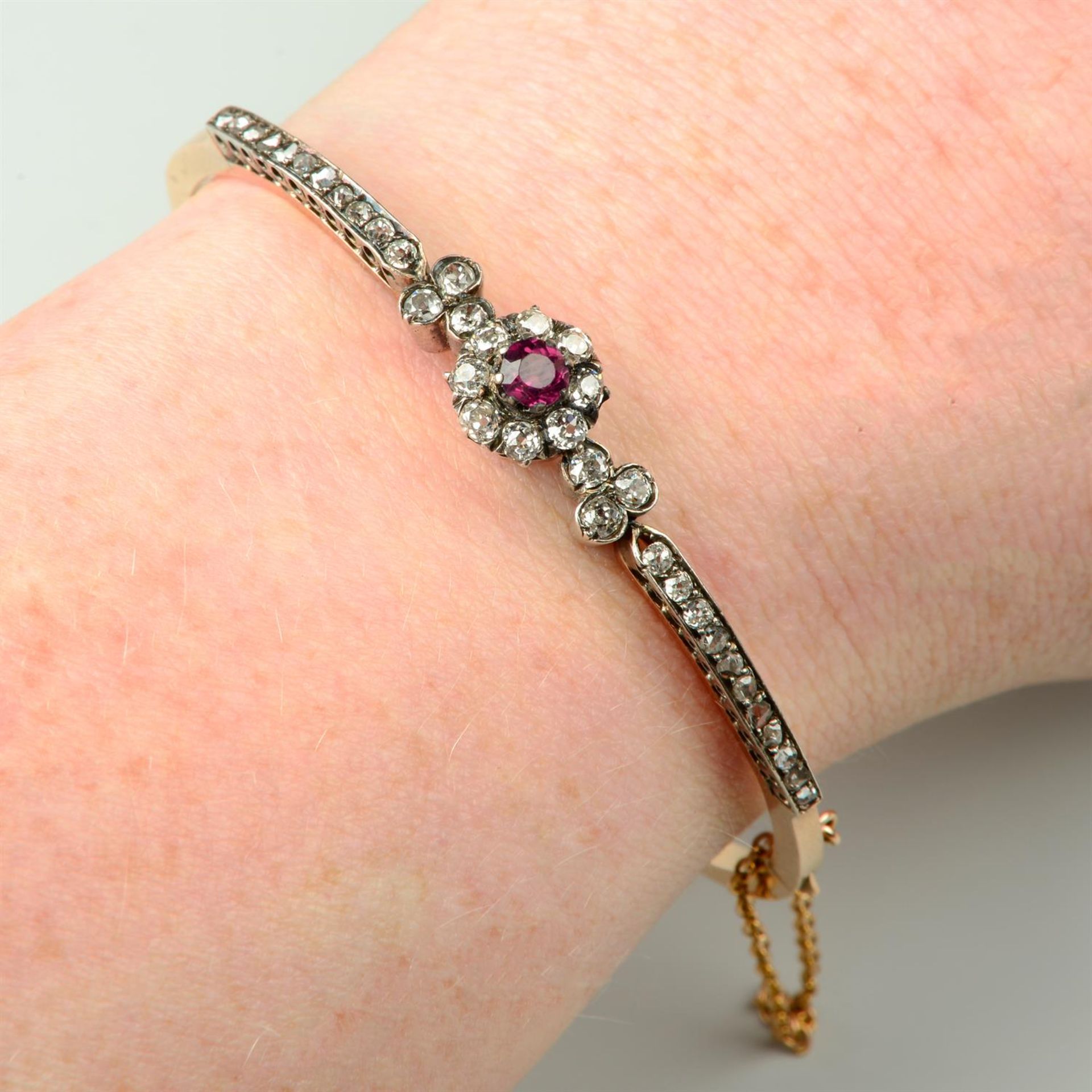 A late Victorian silver and 18ct gold, garnet old and rose-cut diamond hinged bangle.