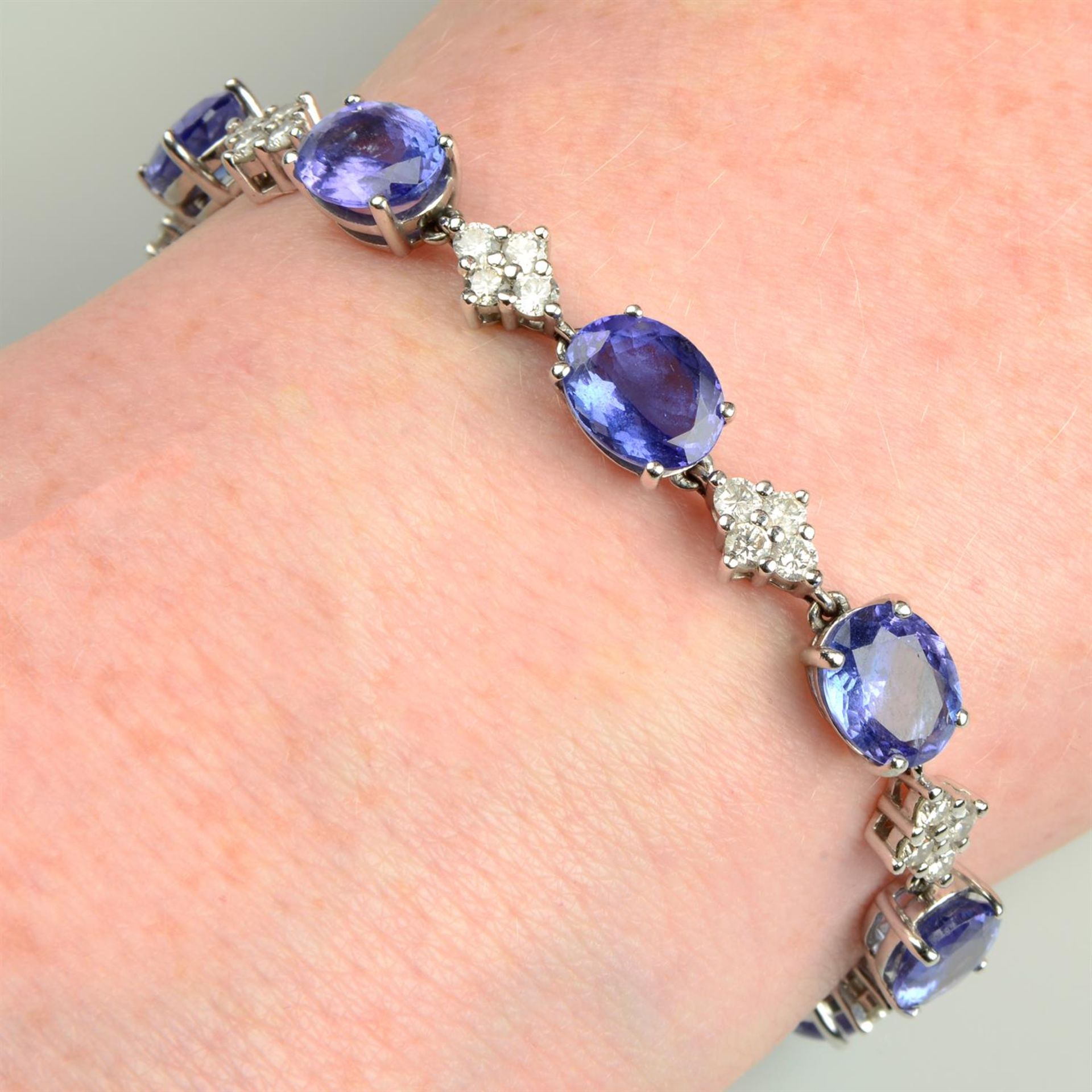 A tanzanite line bracelet, with brilliant-cut diamond quatrefoil spacers.