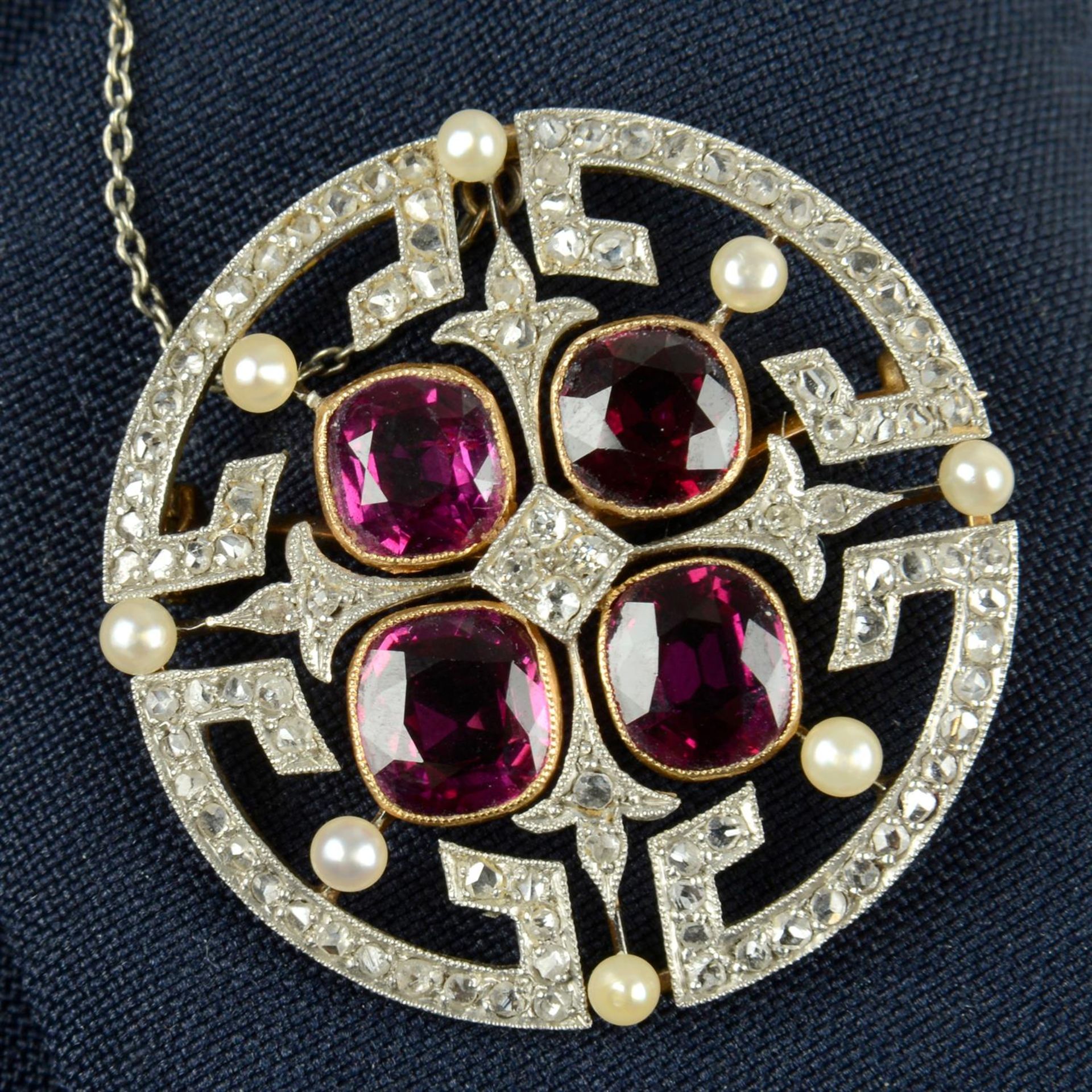 An Edwardian platinum and 15ct gold ruby, seed pearl and vari-cut diamond geometric brooch.