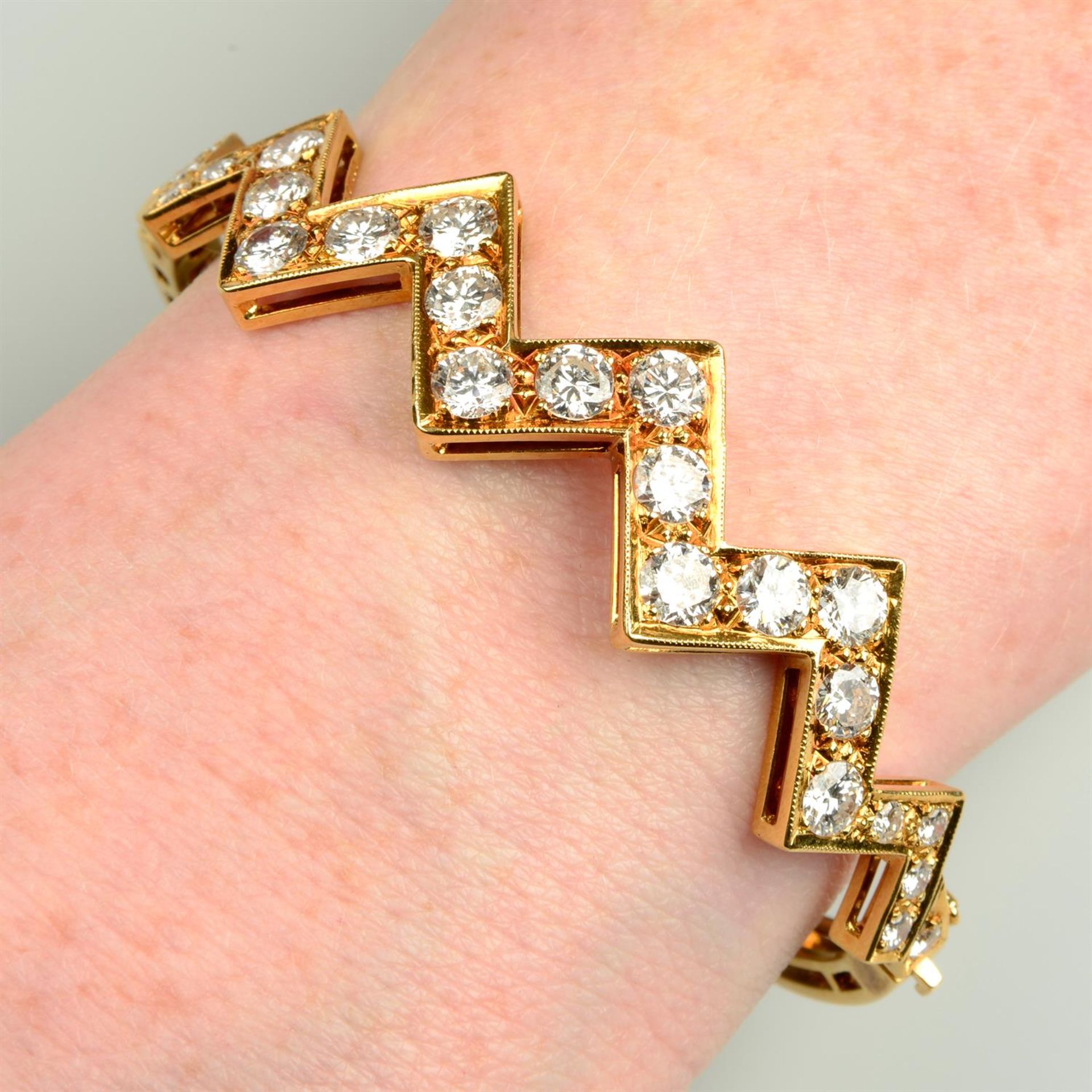 An 18ct gold brilliant-cut diamond geometric 'zig zag' hinged bangle.